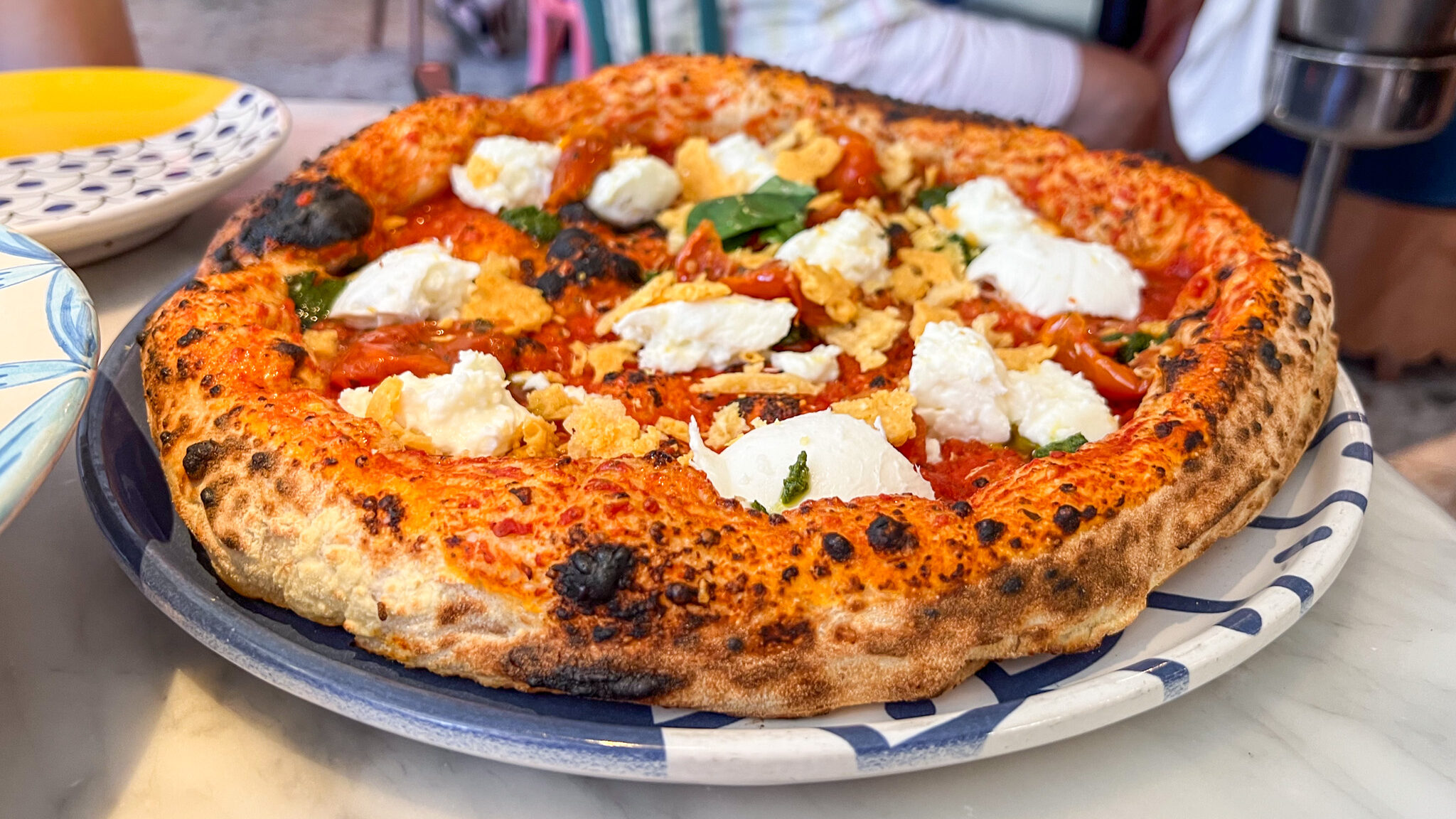 Large pizza with burrata and parmesan crust.