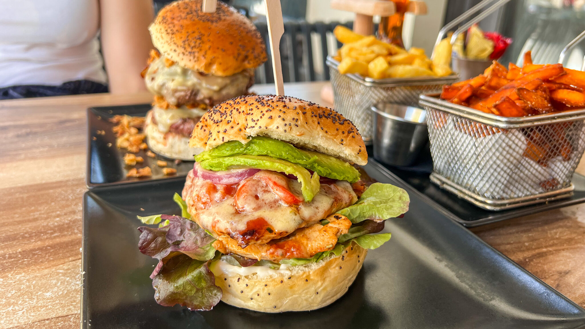 Chicken burger on seeded bun with sides.