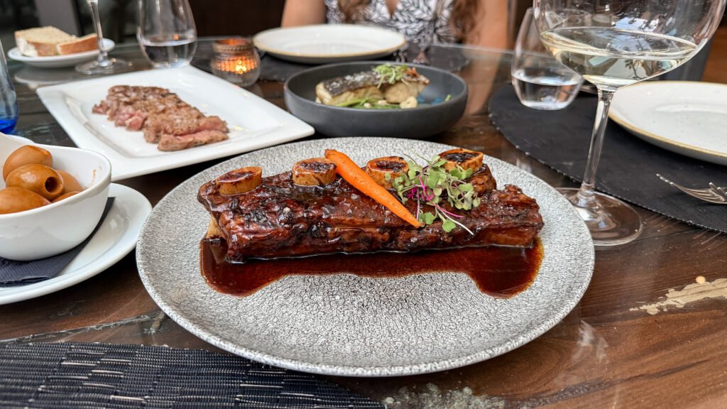 Restaurante Montana Malaga | Krista the Explorer Restaurant in courtyard with ribs in sauce on plate.