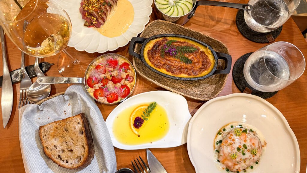 Selection of fine-dining dishes on wooden table in new restaurant.