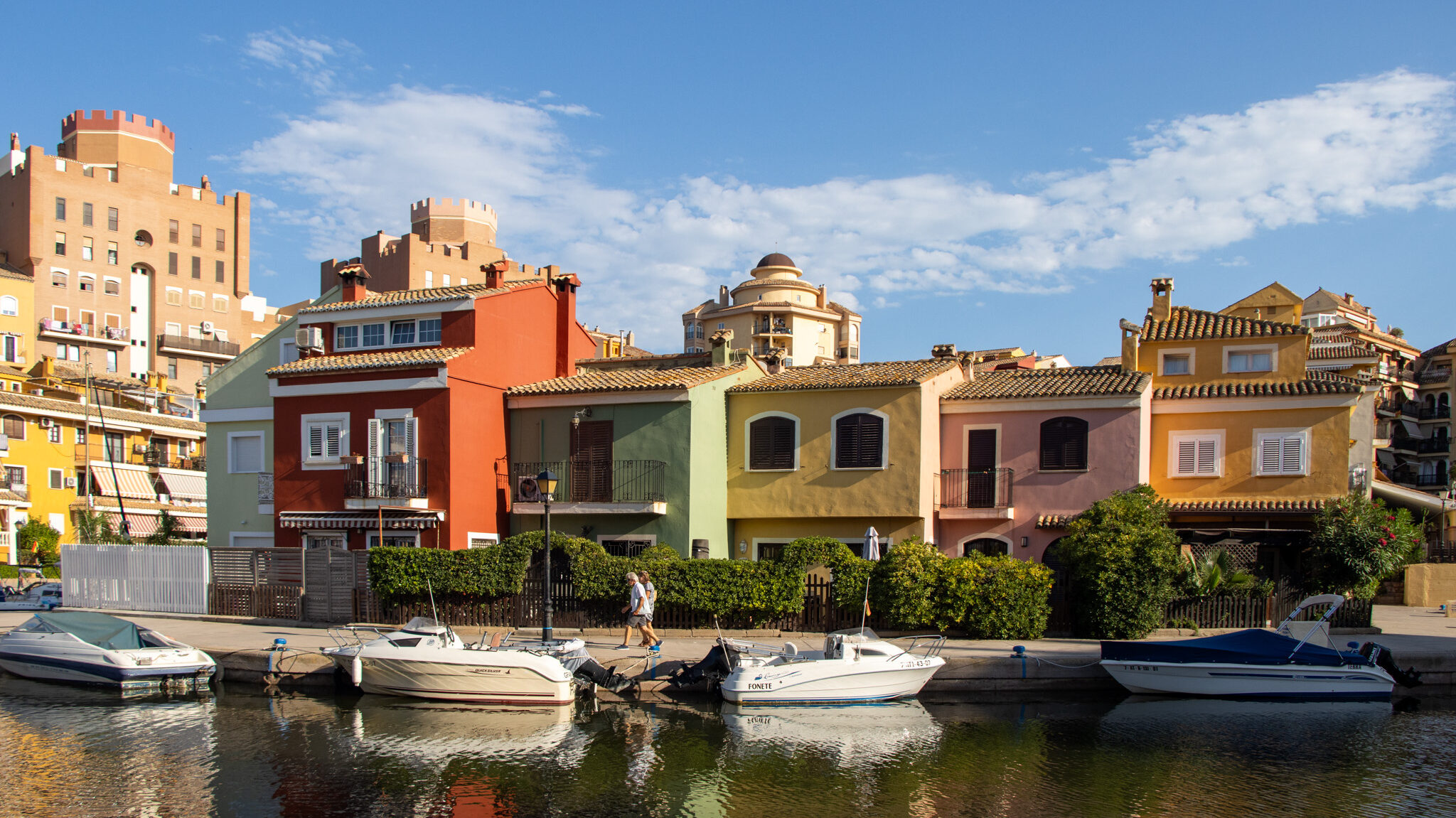 Colourful buildings along canals with boats docked.