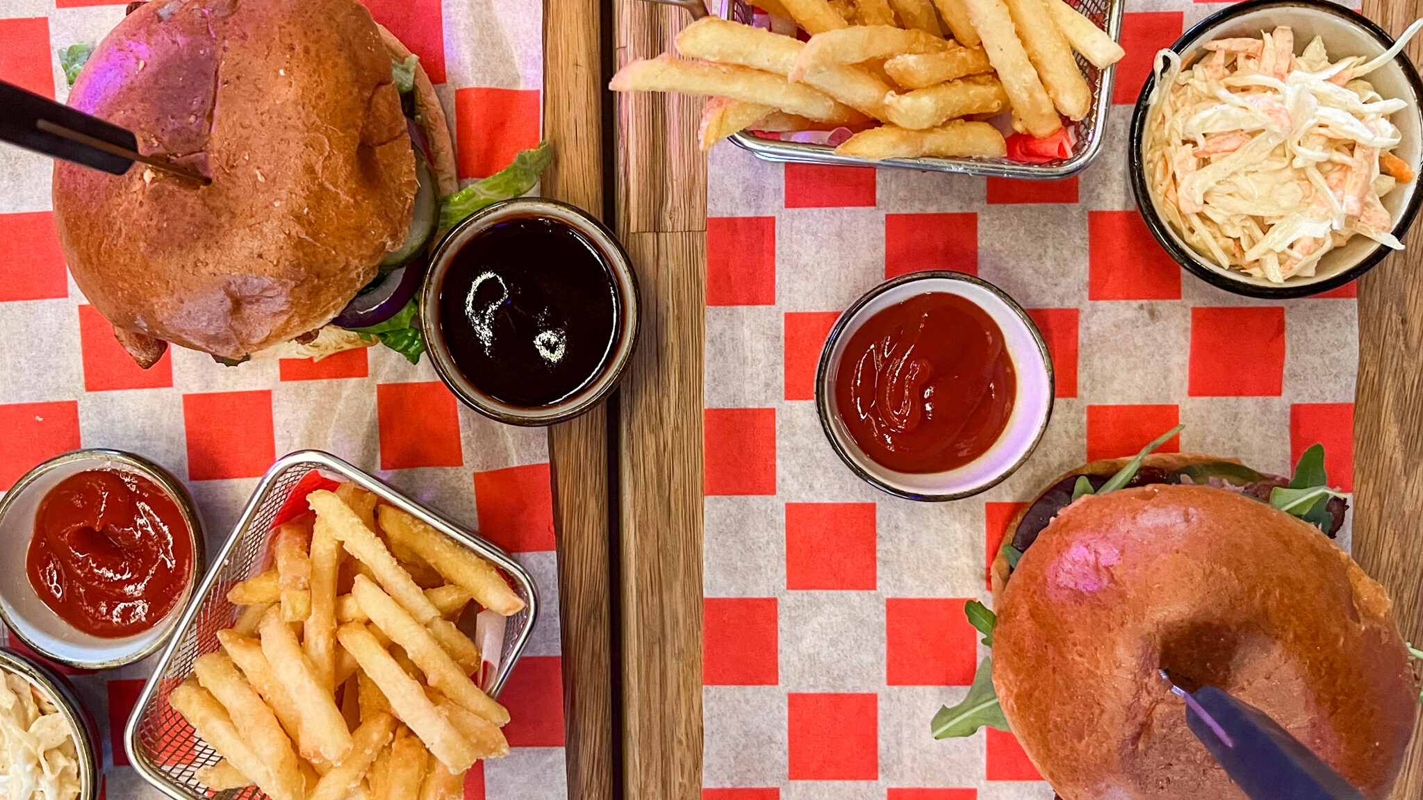 Two wooden boards with burgers and fries.