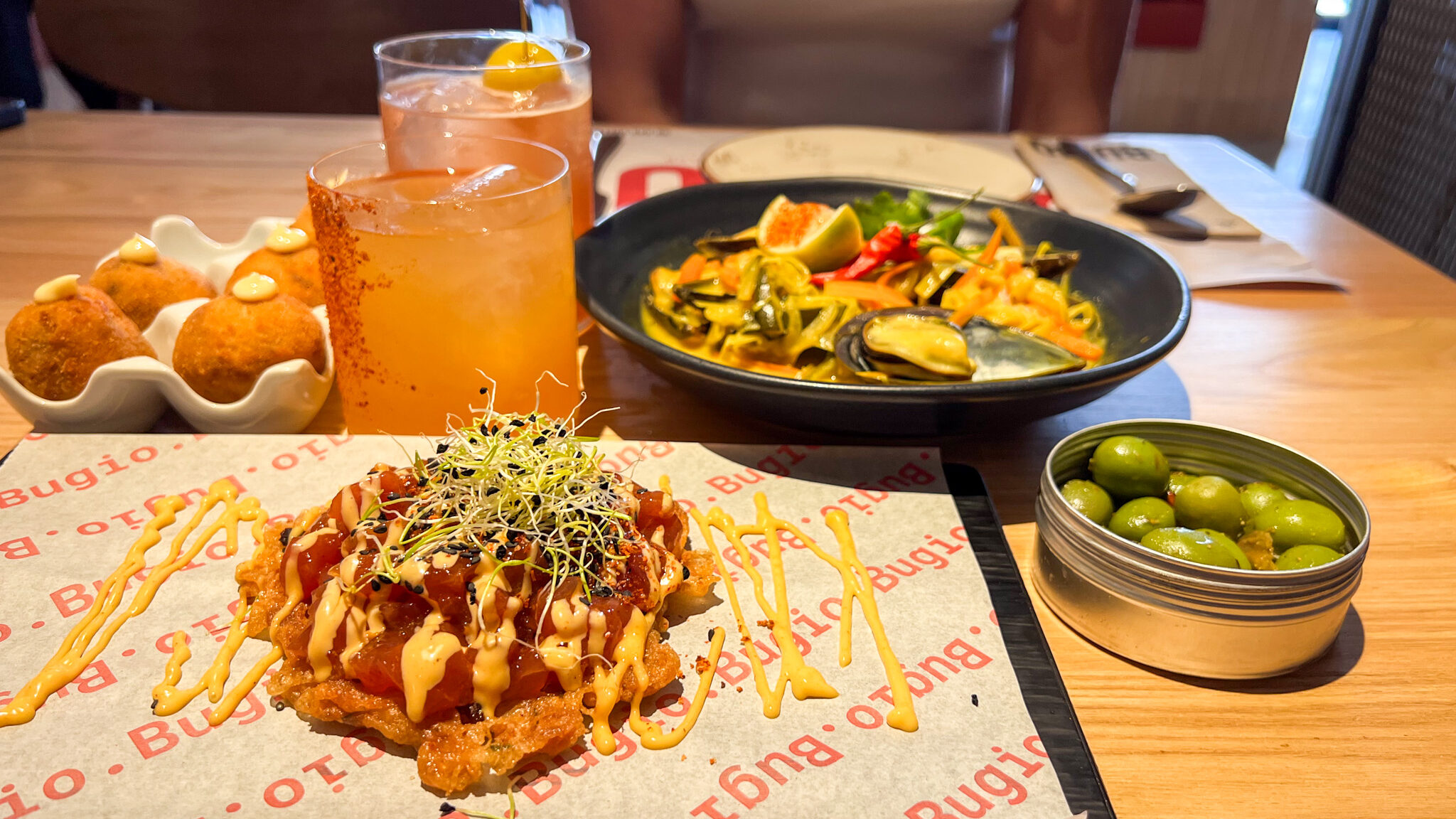 Selection of starters with two cocktails on table.