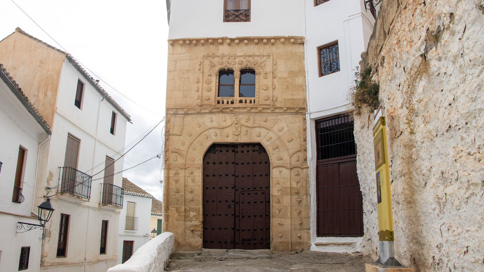 House next to church with wooden doors.