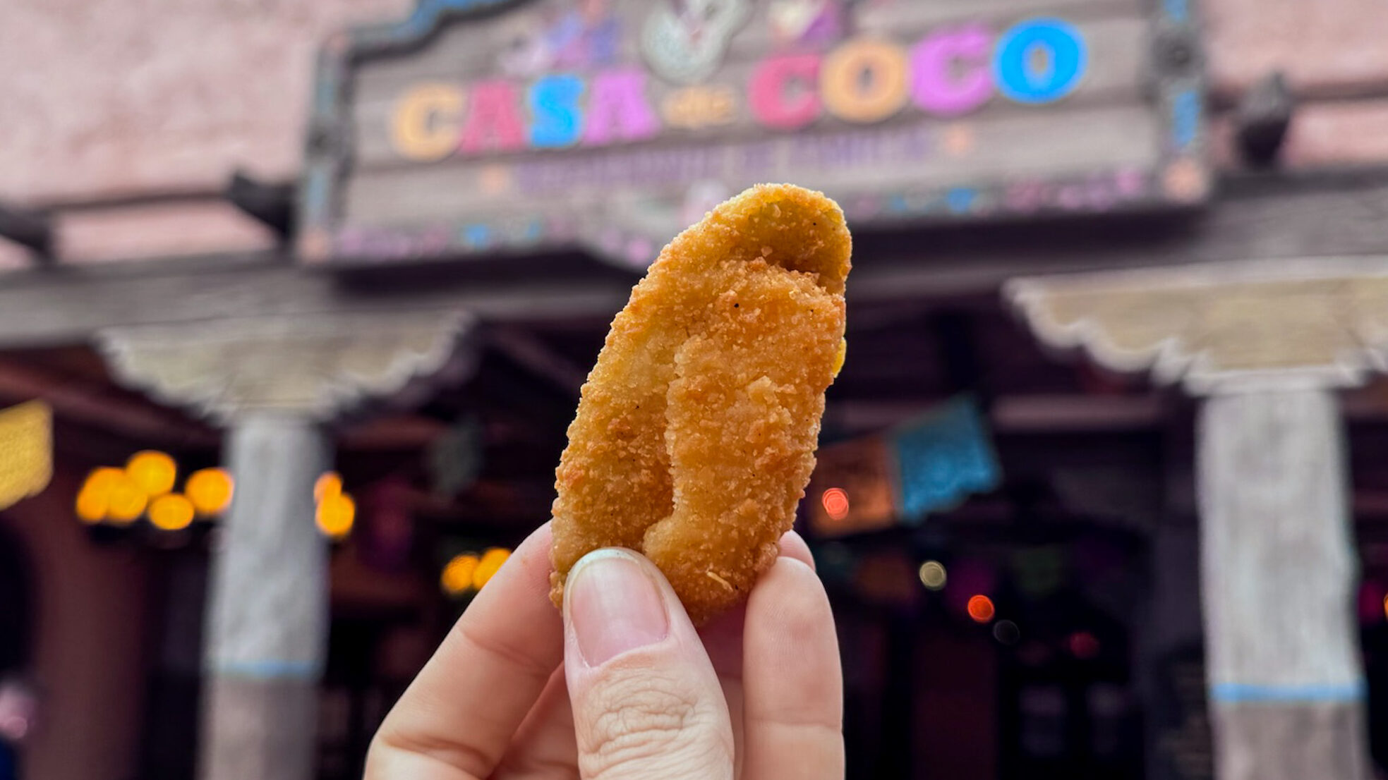 Jalapeno Cheese Bite held up in front of restaurant.