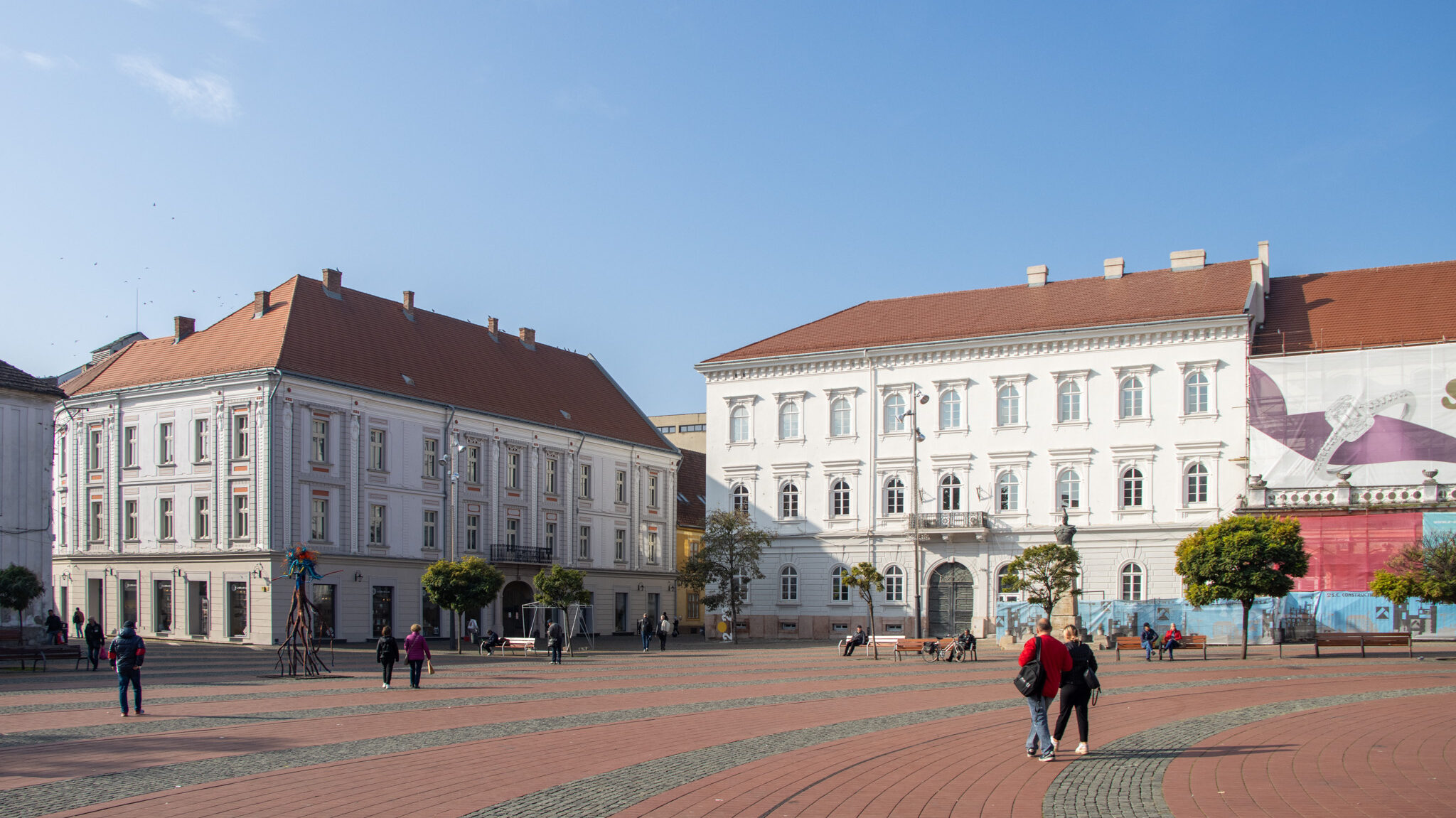 Large square in Timisoara with white painted buildings.