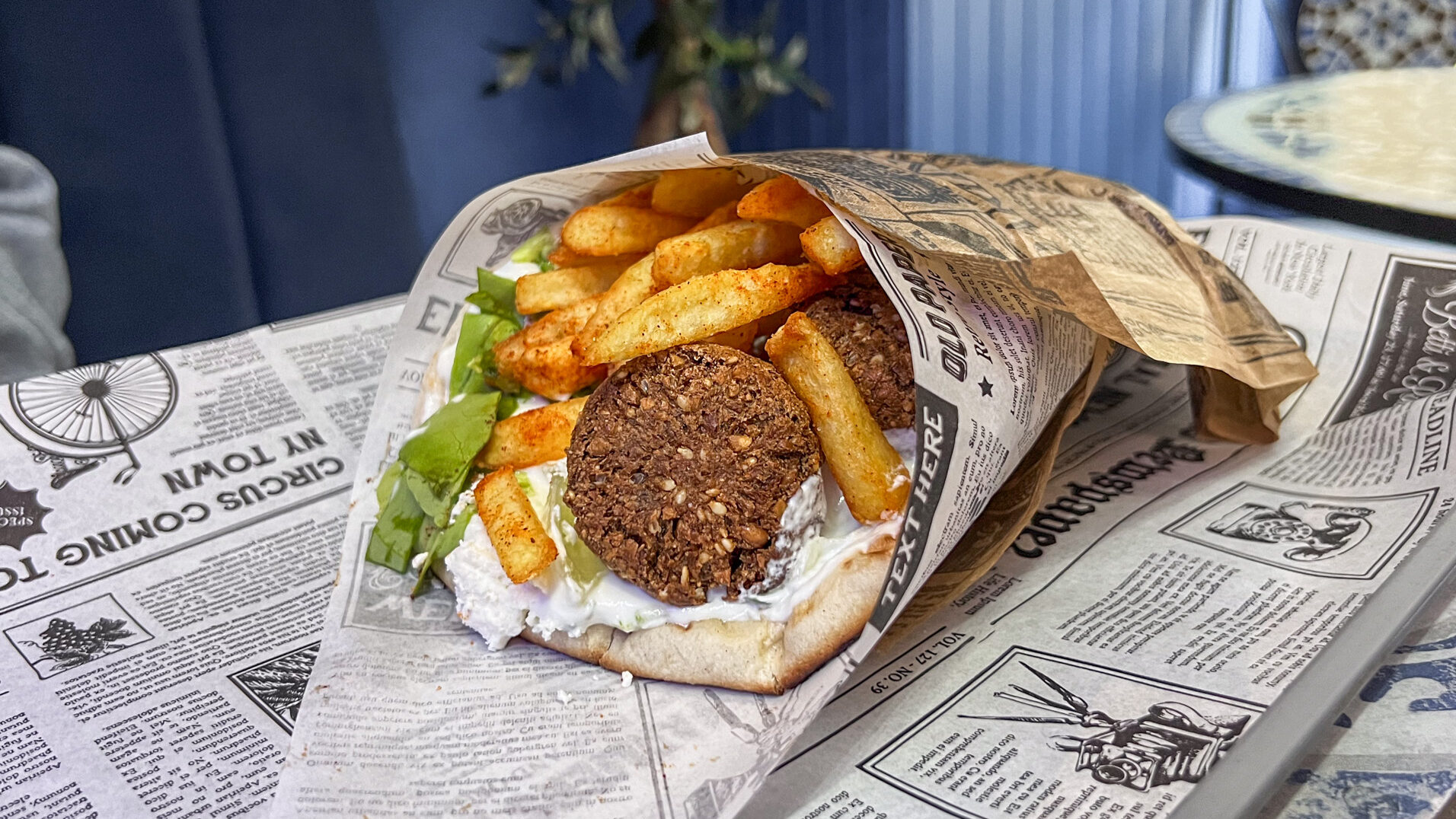 Falafel wrap with fries and salad inside.