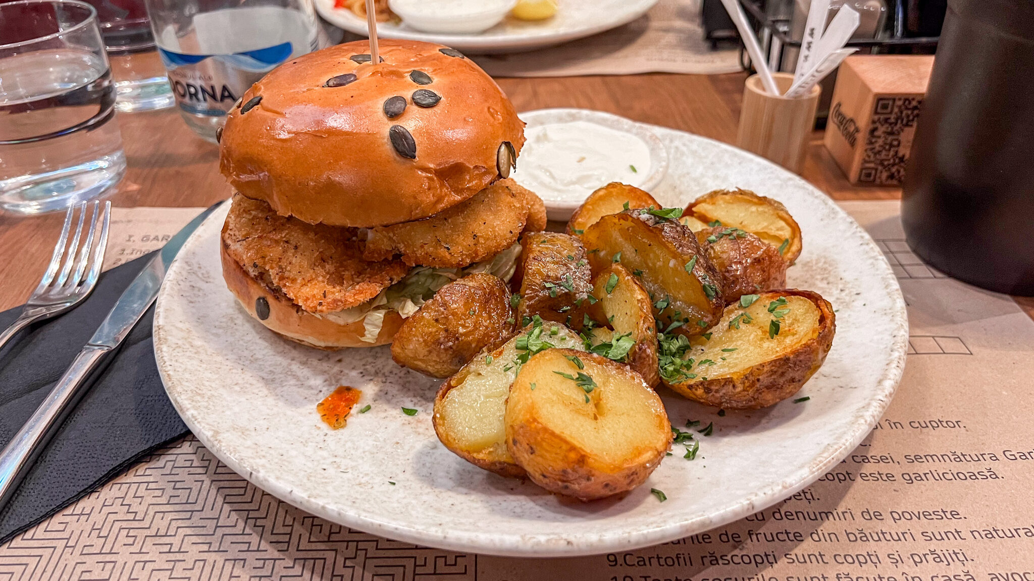 Crispy chicken burger with a side of roasted potatoes. 