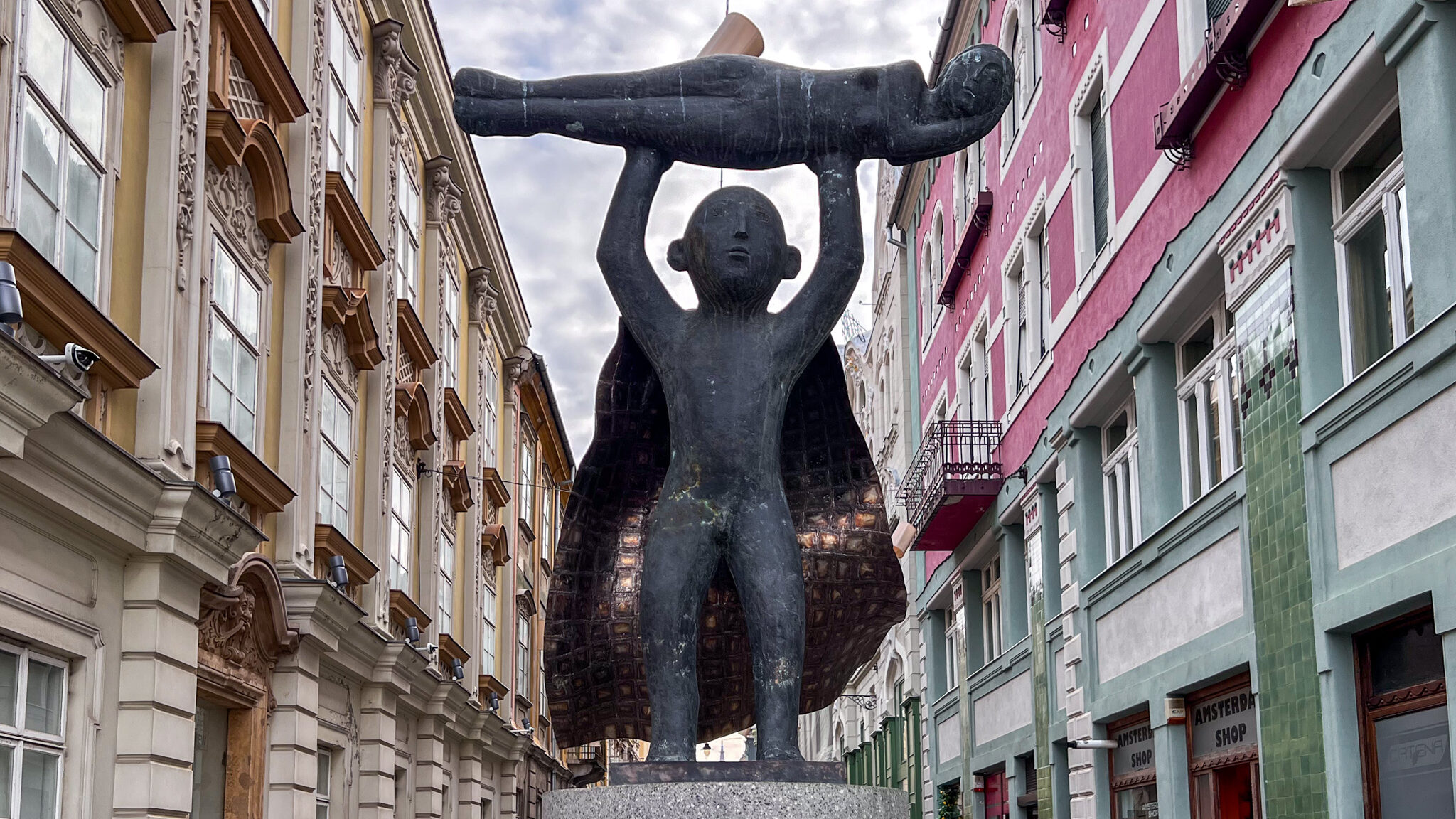 Statue of young child with cape.