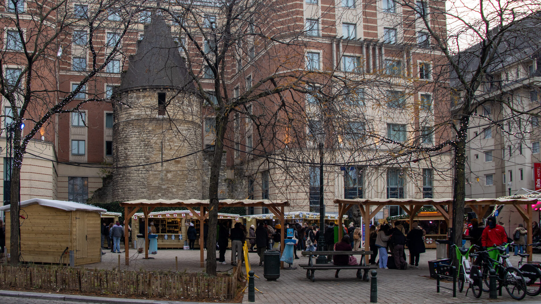 Small historic tower among modern buildings.