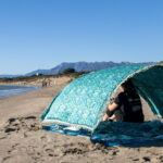 Beach canopy with colourful towel under.