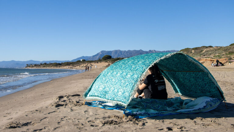 Beach canopy with colourful towel under.