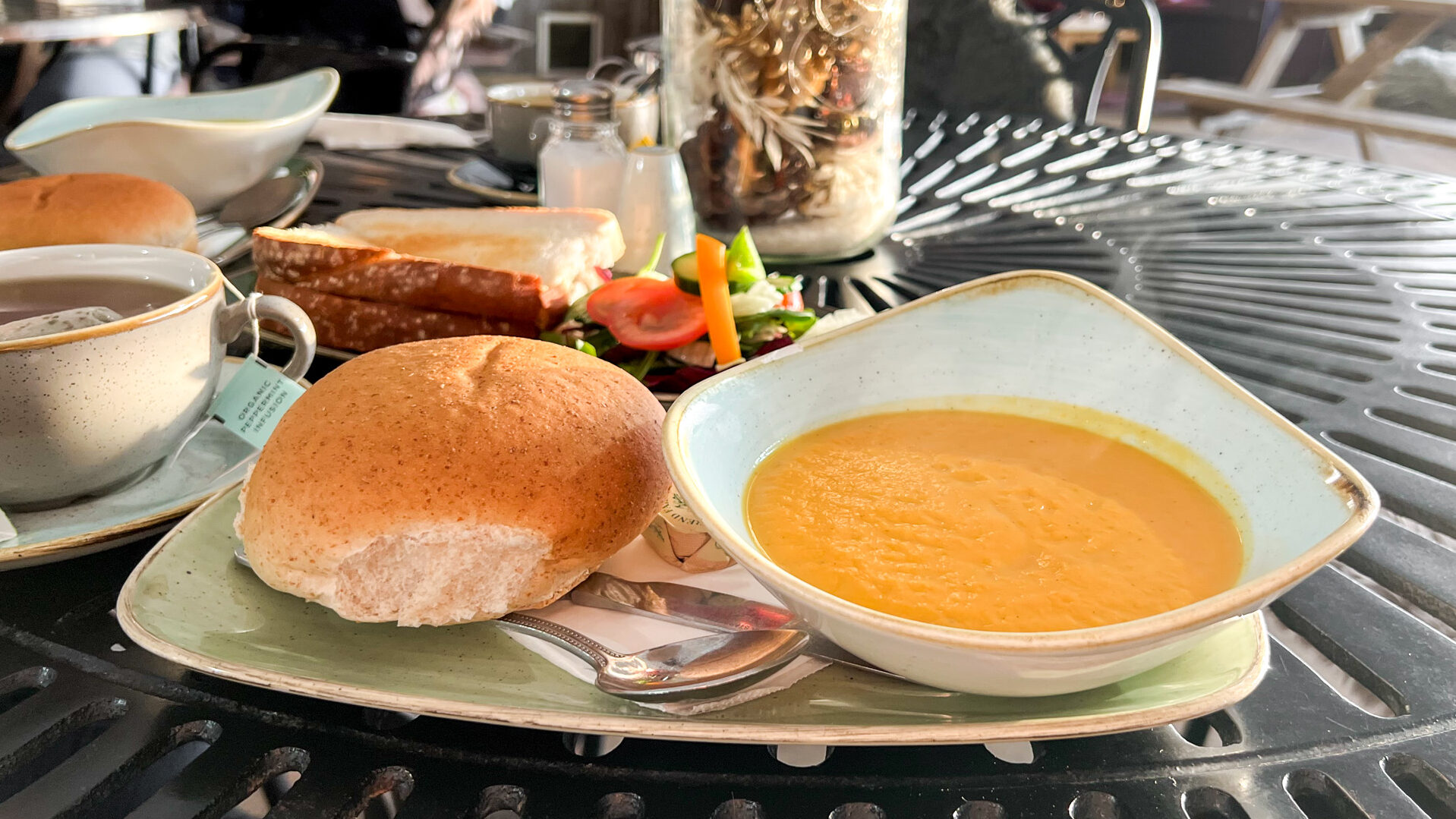 Seasonal soup and bread roll on table.