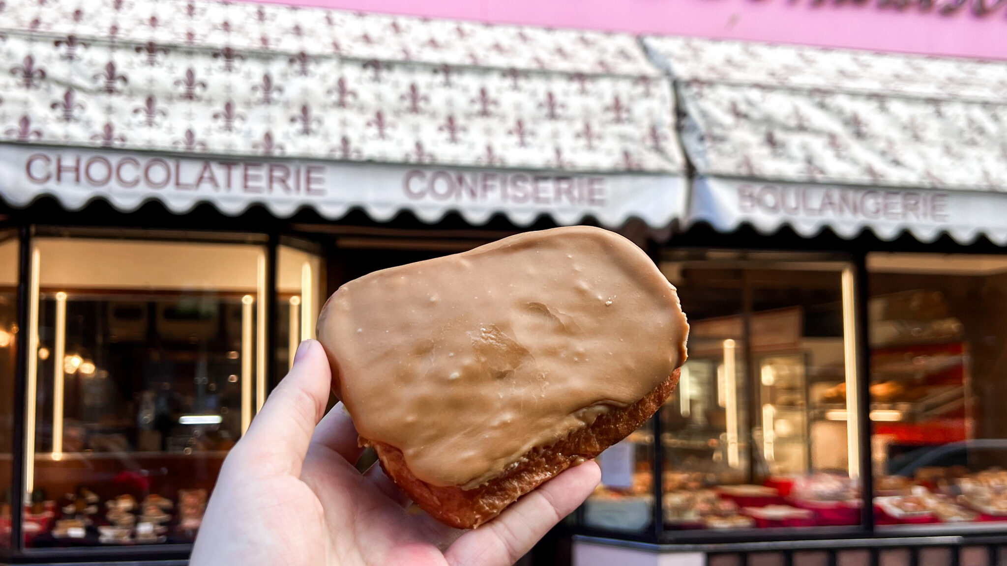 Large fudge doughnut in front of bakery.