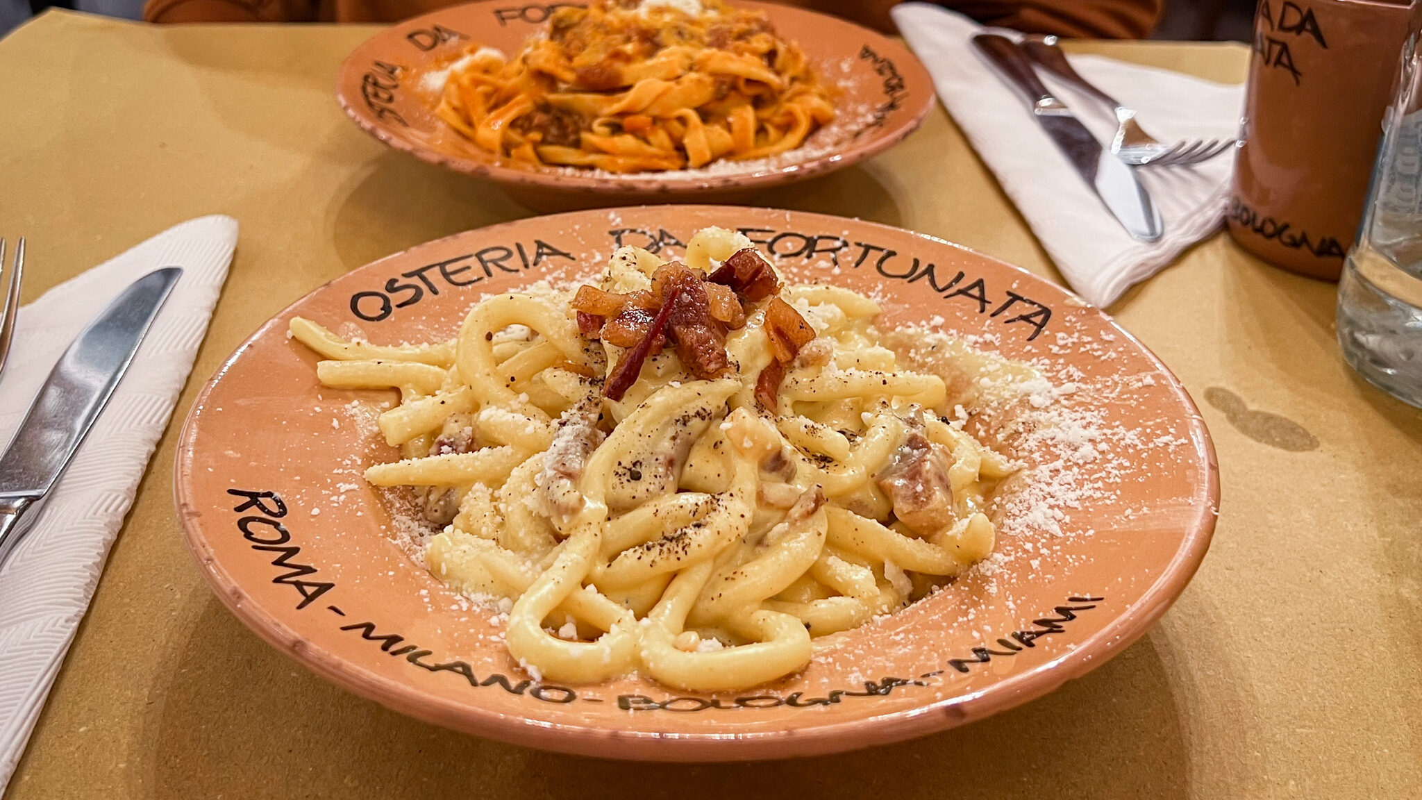 Two plates of fresh pasta in Roman restaurant.