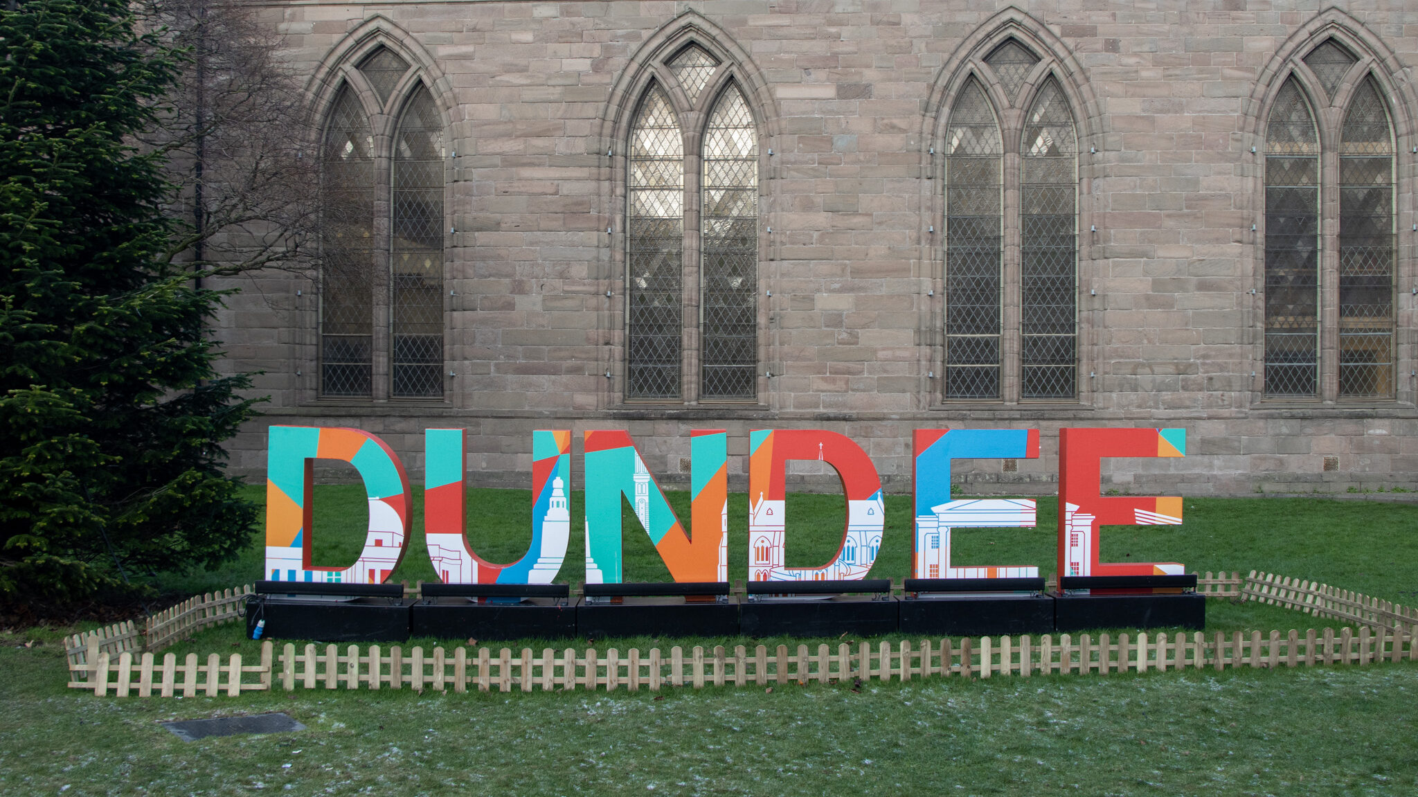 Colourful Dundee sign in front of church.