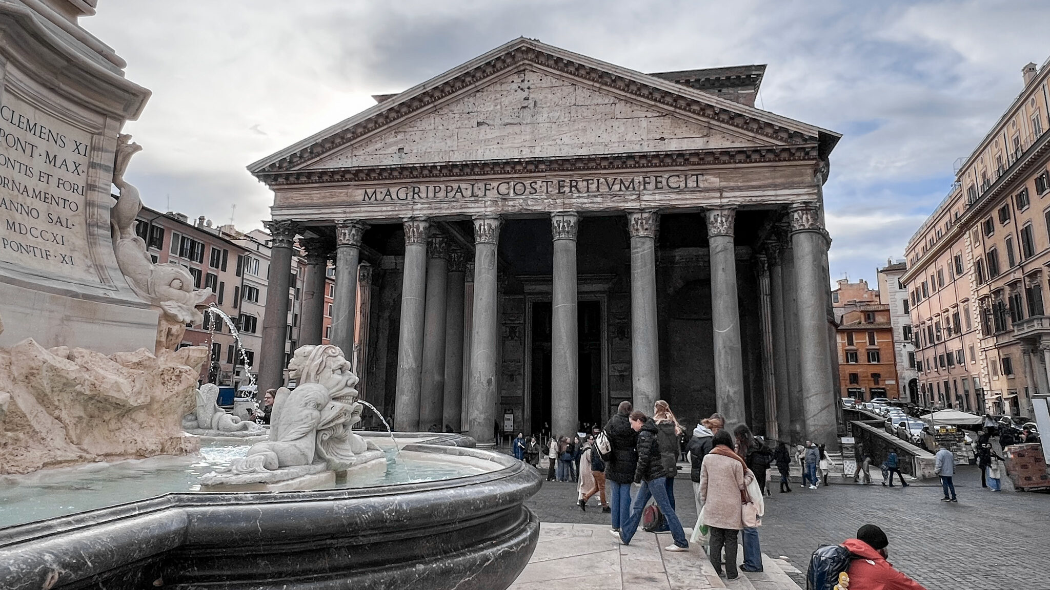 Exterior of the Pantheon in Rome with water fountain in front.