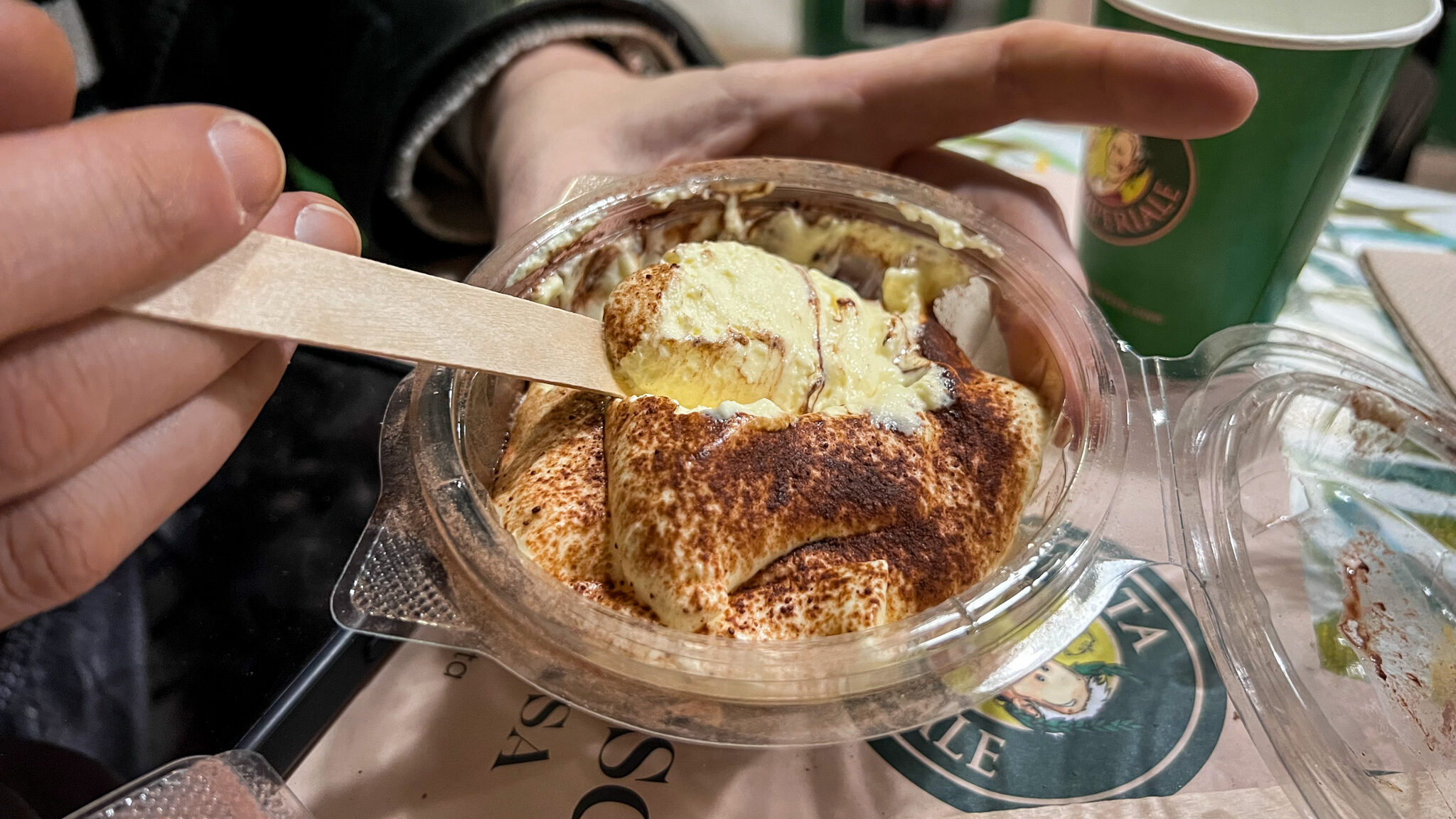 Classic tiramisu served in plastic container.