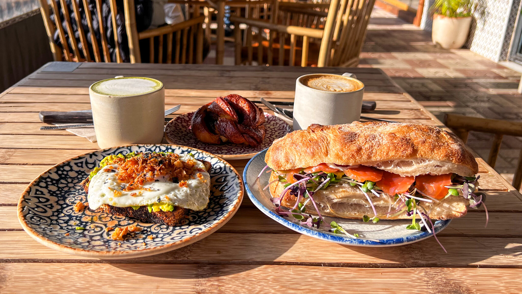 Sandwich and egg on toast in sunlight on table.