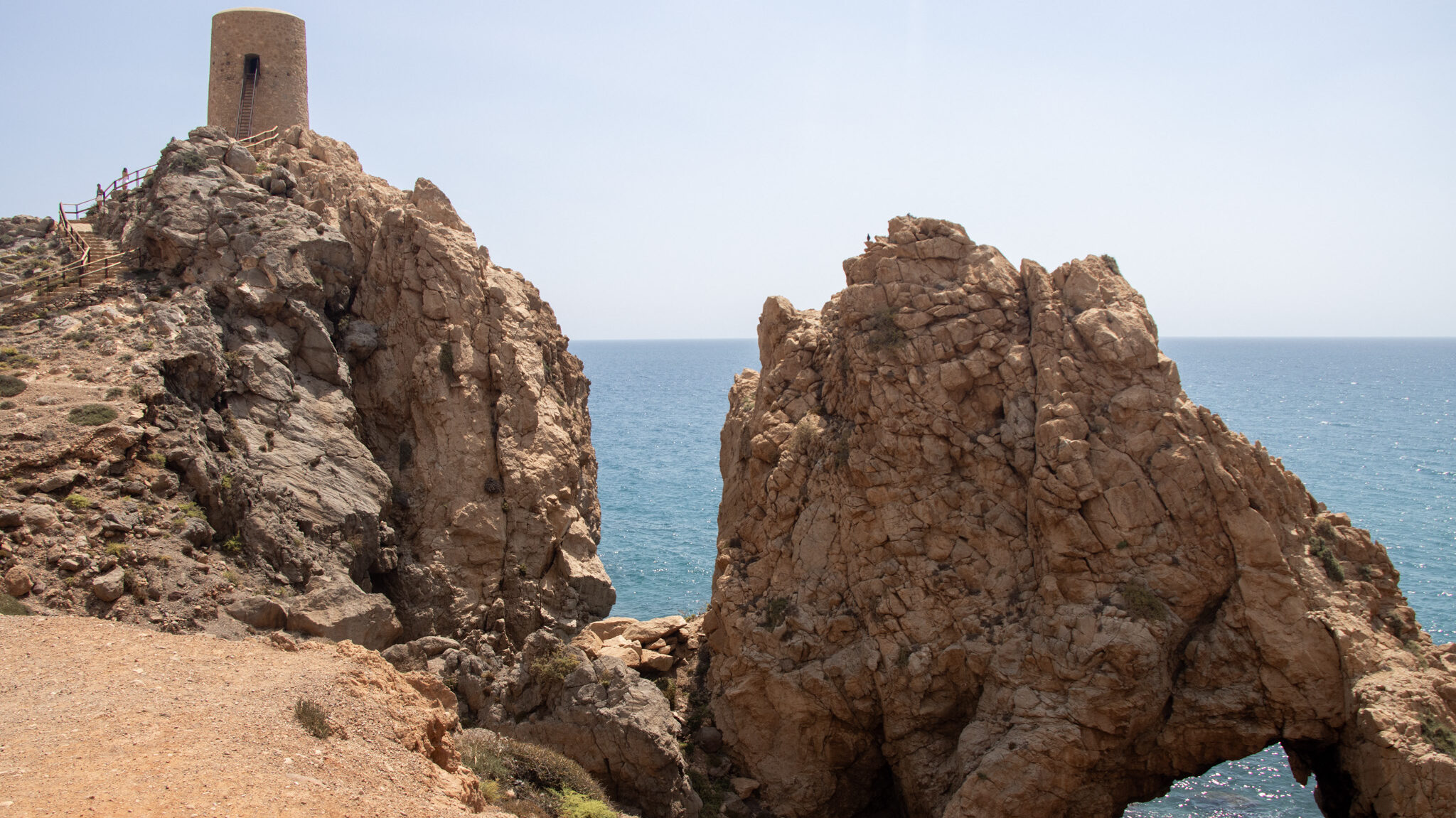 Torre Mojacar | Krista the Explorer Watchtower on cliffside next to stone arch.