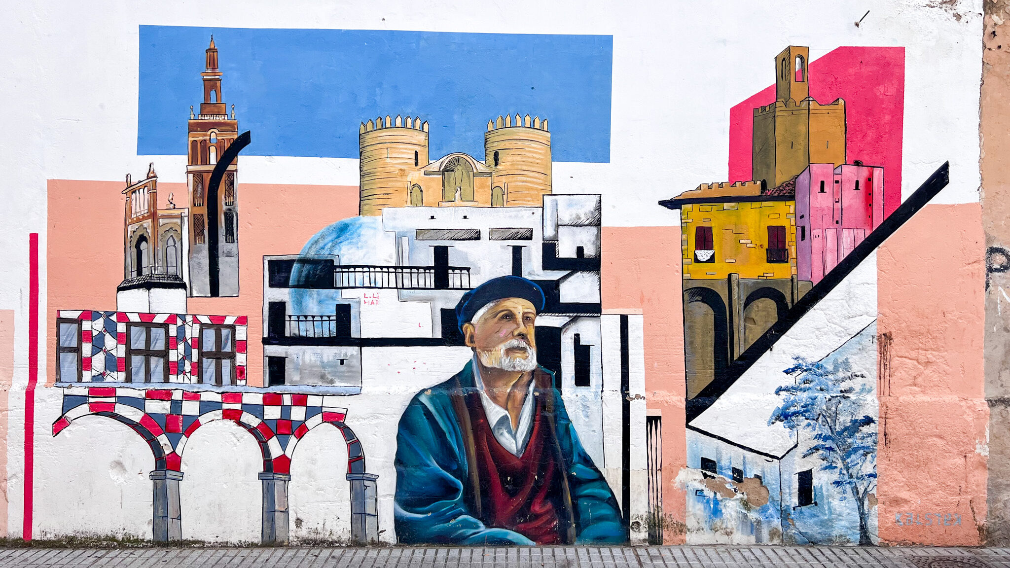 Street Art Badajoz | Krista the Explorer Colourful painting of old town on white wall.