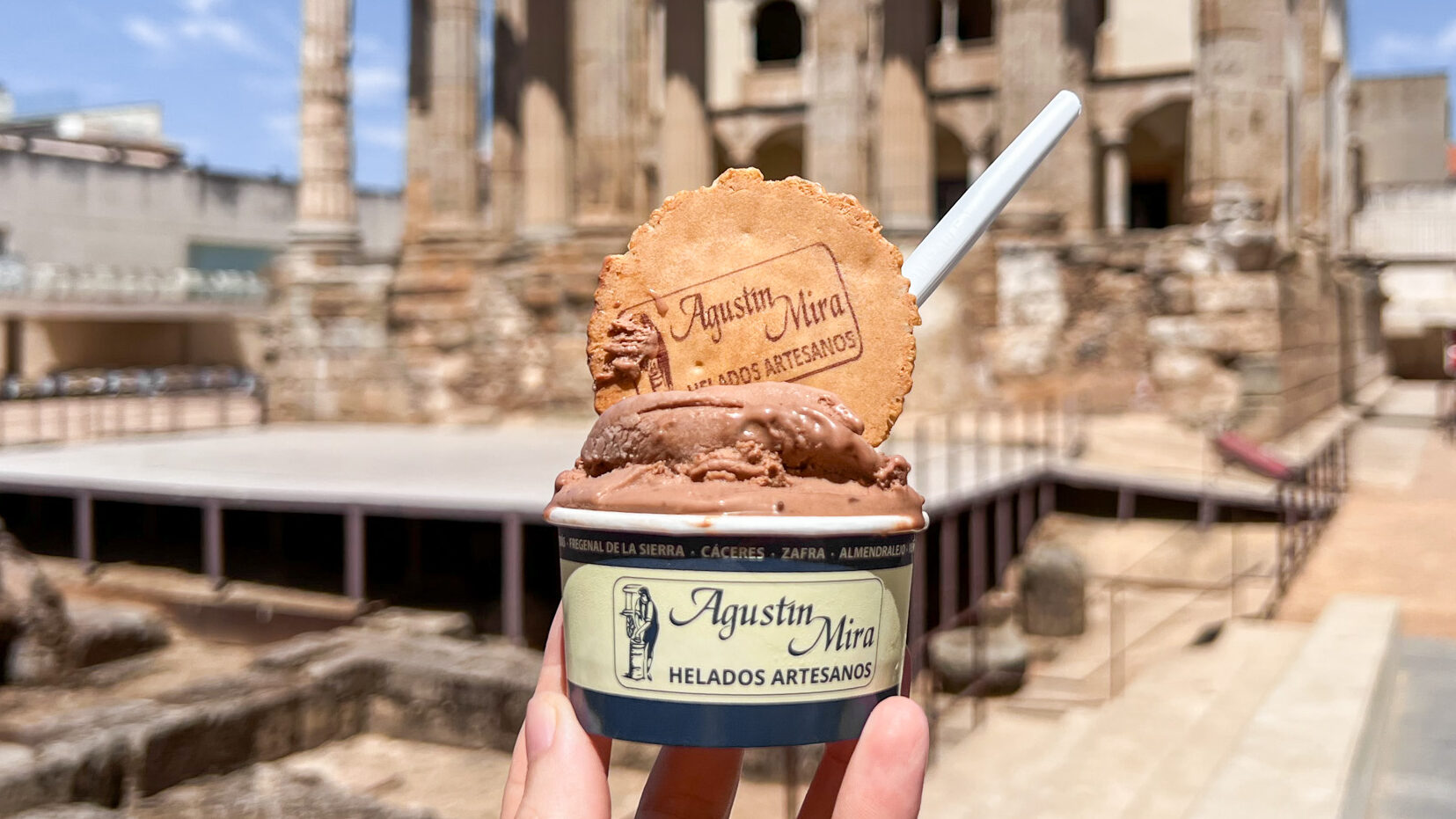 Heladeria Artesana Agustin Mira Merida | Krista the Explorer Chocolate ice cream in tub held up in front of Roman temple.