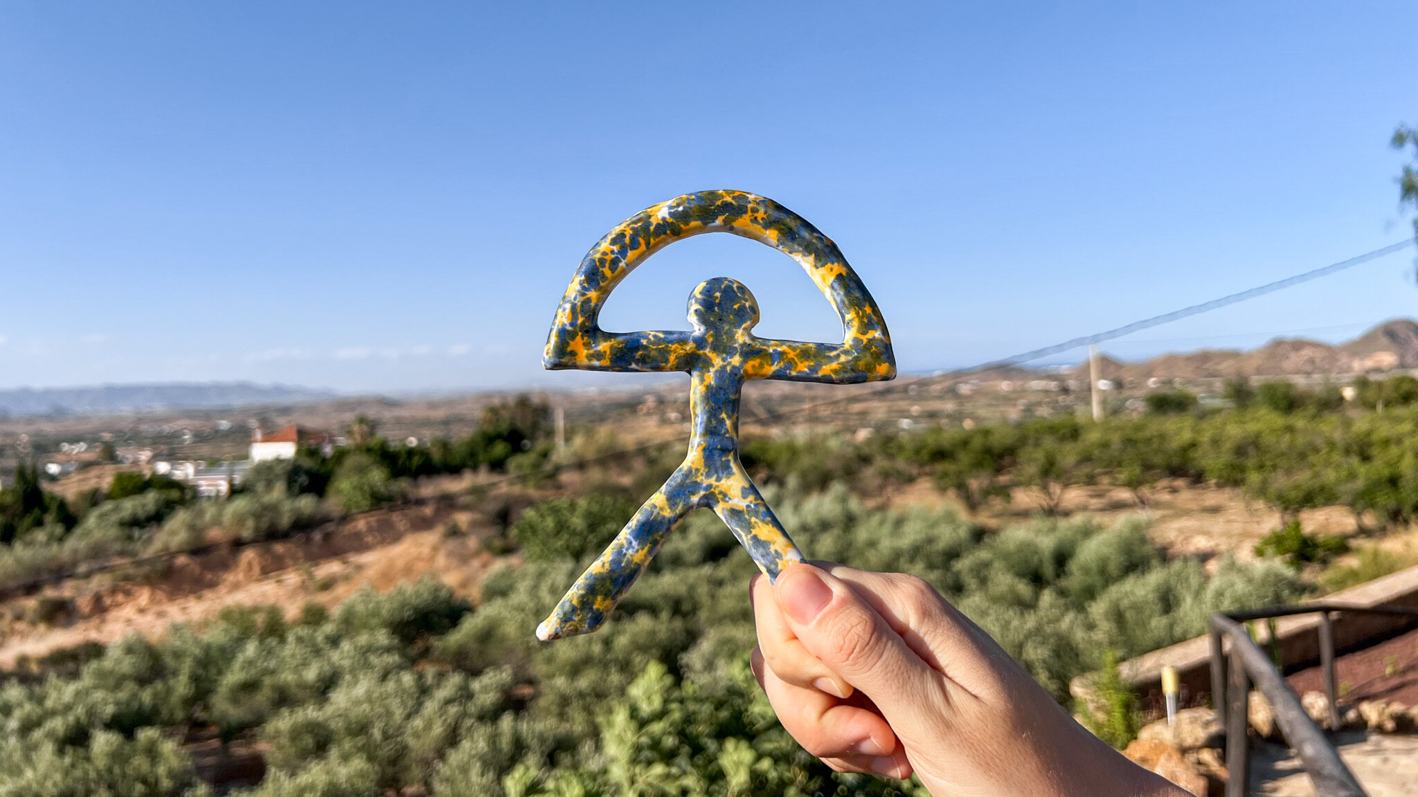 Indalo Mojacar | Krista the Explorer Handmade Indalo symbol painted blue and yellow.