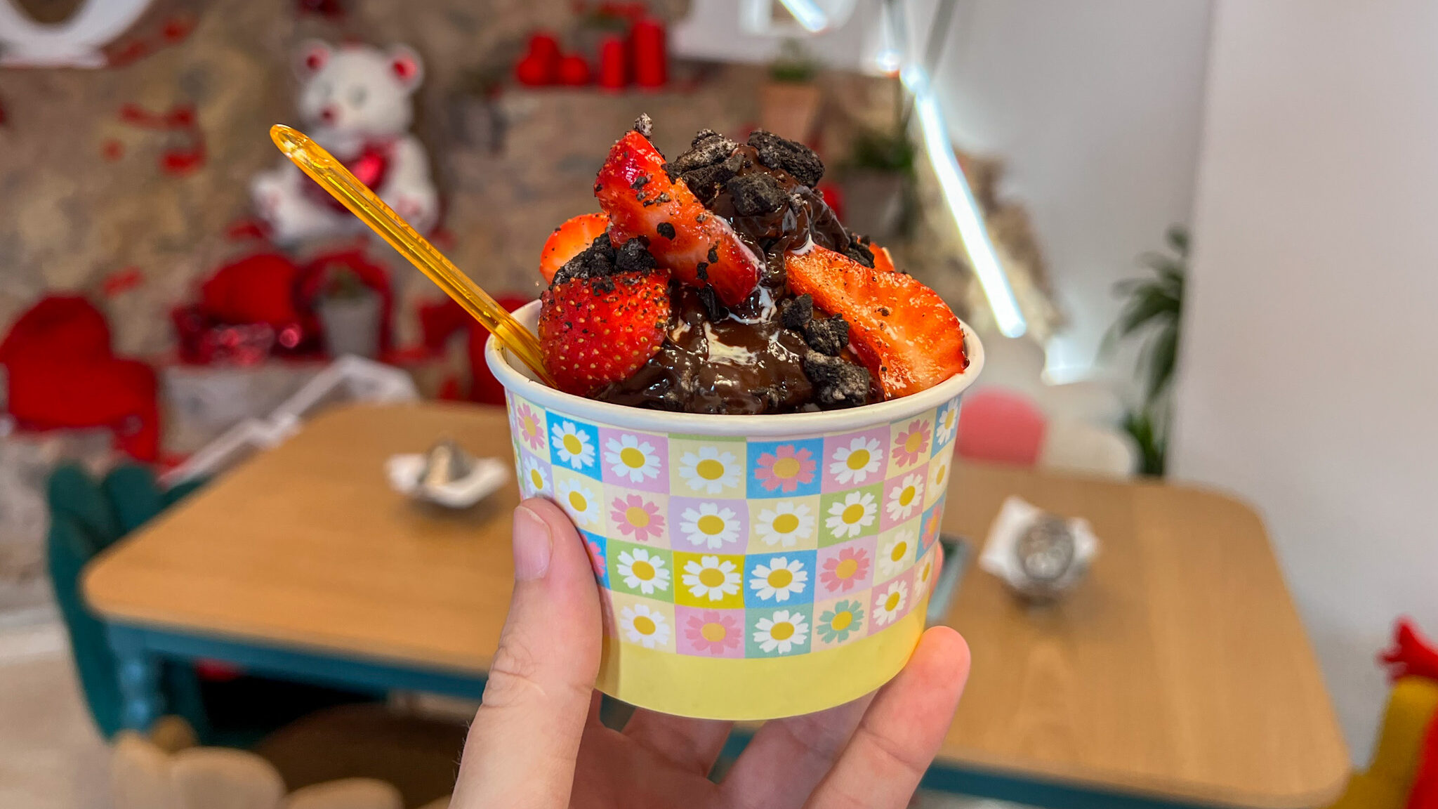 Bowl of frozen yogurt topped with sauce and fruit.