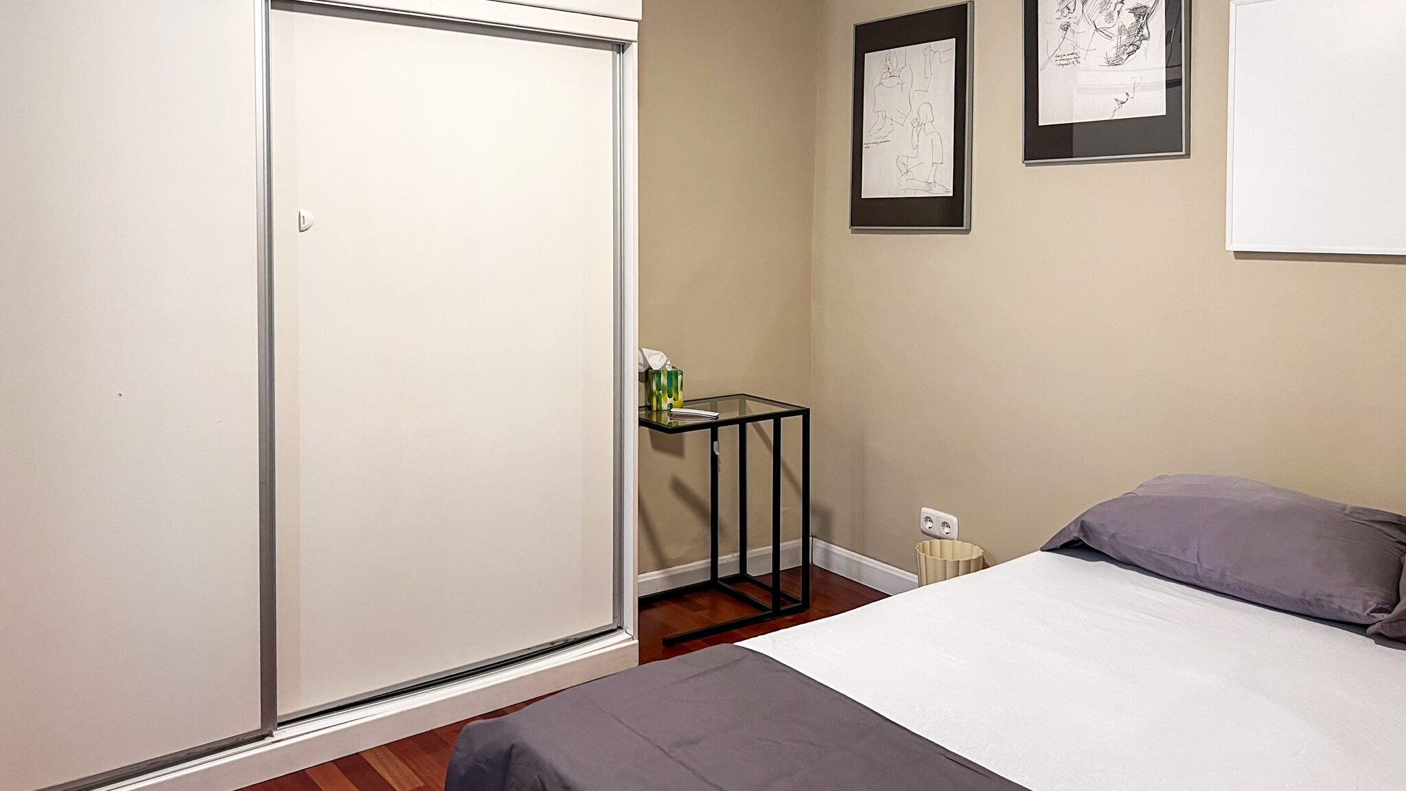 Simple double bed inside room with white closet.