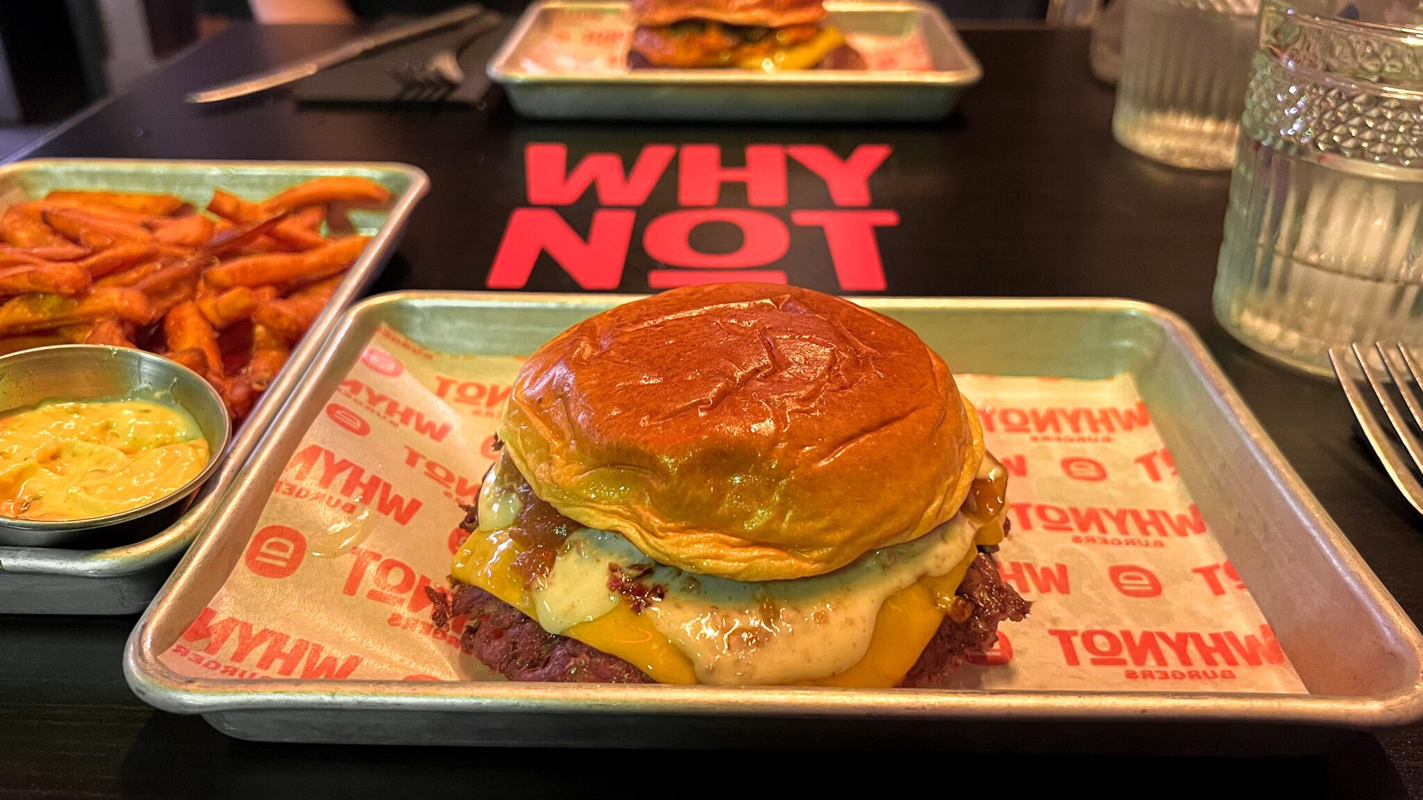 Smash burger with cheese served on tin tray.