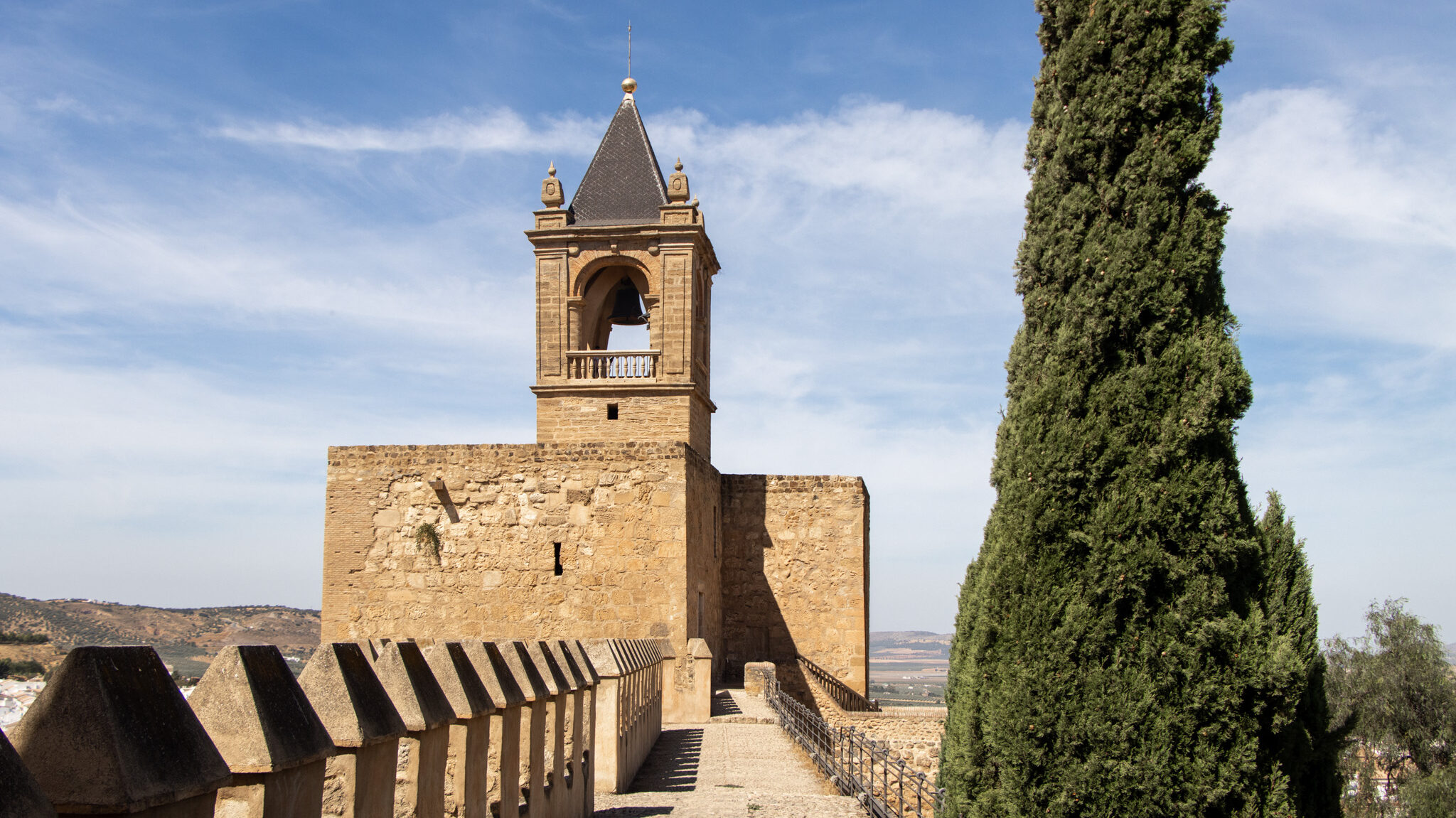 Fortress wall leading up to square tower.