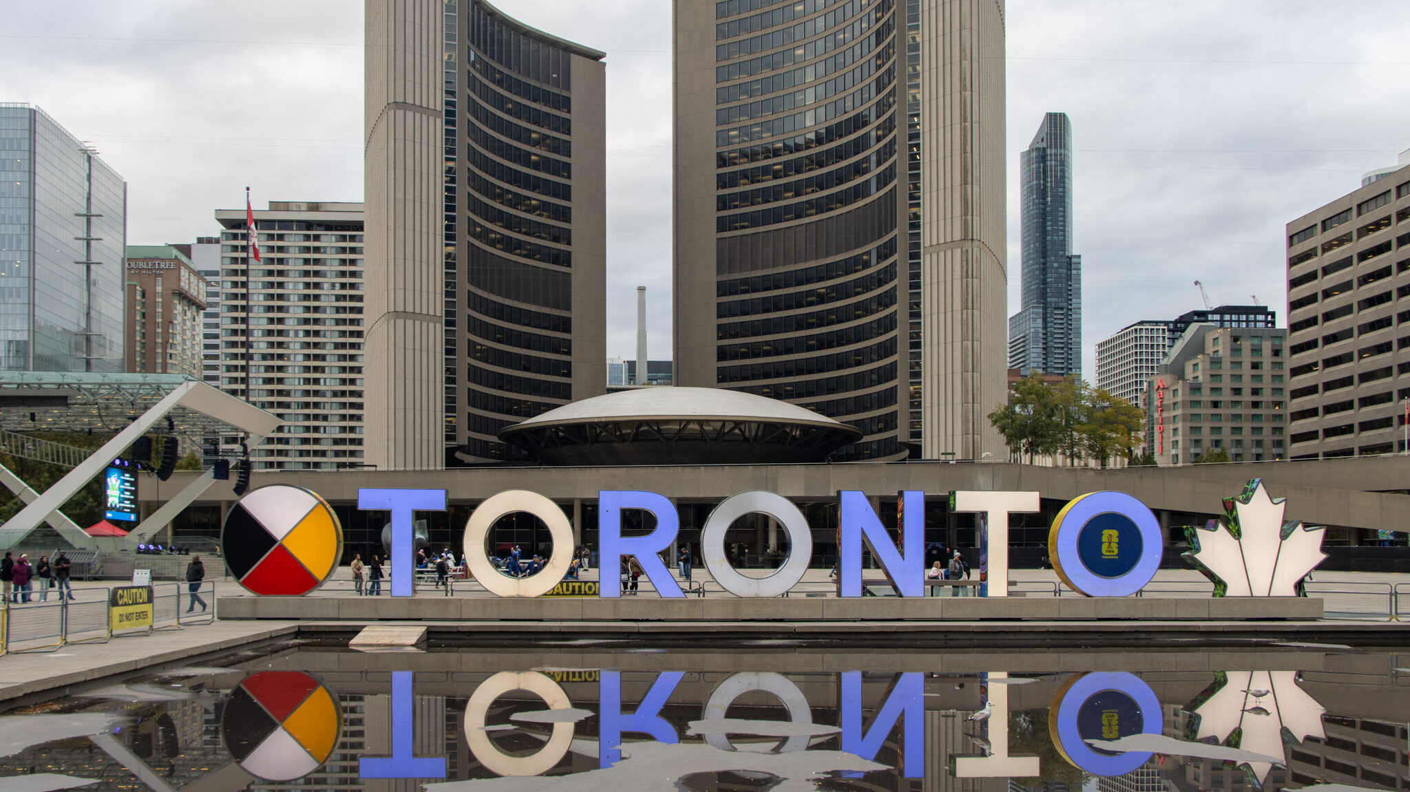 Nathan Phillips Square Toronto | Krista the Explorer Toronto sign in blue and white in front of city hall.