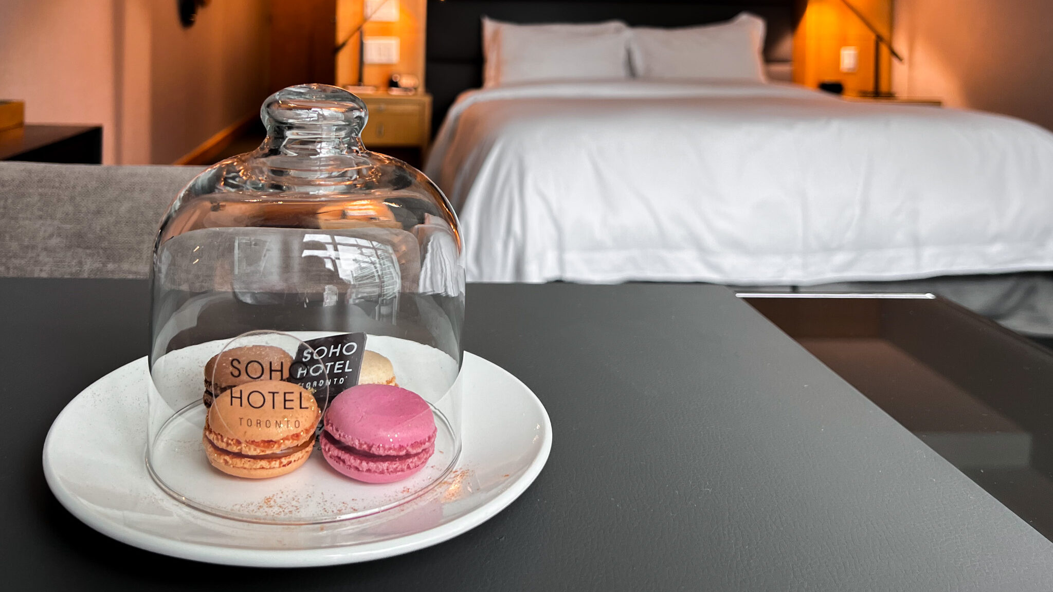 SoHo Hotel Toronto | Krista the Explorer Macrons in hotel room next to large bed.
