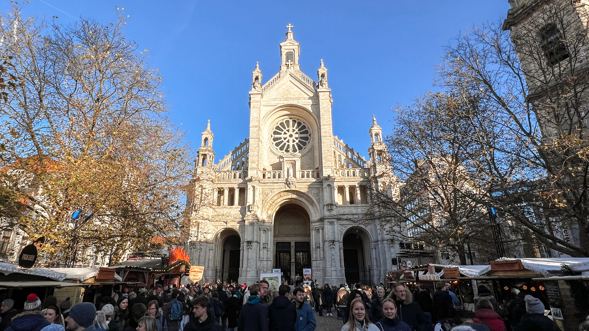 Medieval church in small square with Christmas market in front.
