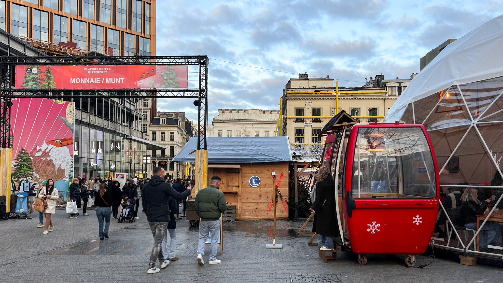 Small Christmas market in Brussels in front of shops.