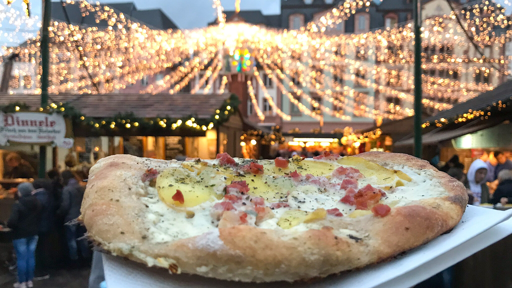 Flatbread with sauce and bacon at Christmas market in Mainz.