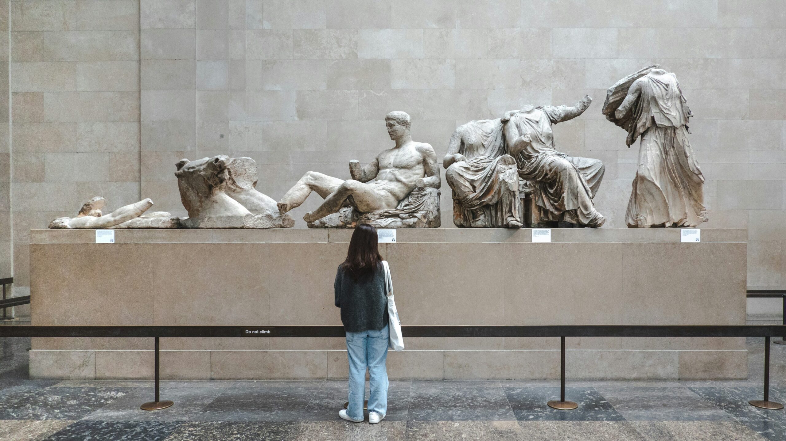 British Museum London | Krista the Explorer Woman looking at ancient statues in museum.