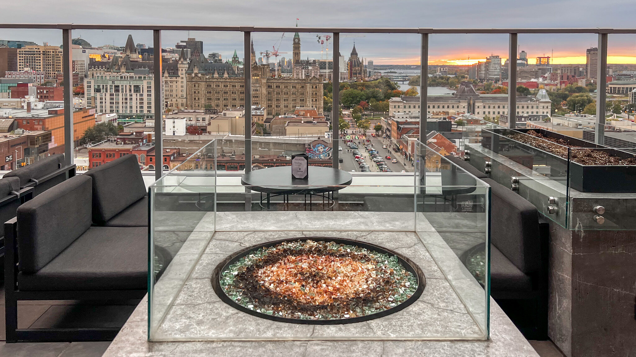 Rooftop Bar Ottawa | Krista the Explorer Fire pit on rooftop bar with sunset city view.