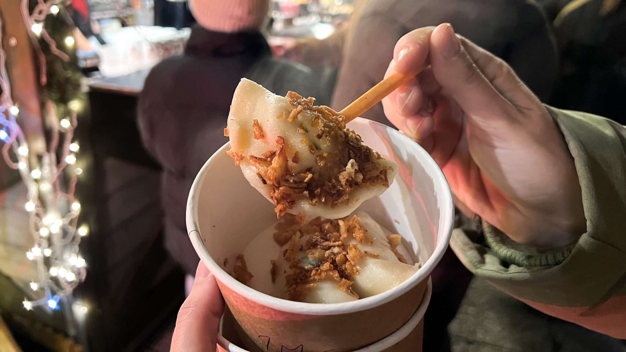 Person holding up pierogi at Gdansk Christmas Market.