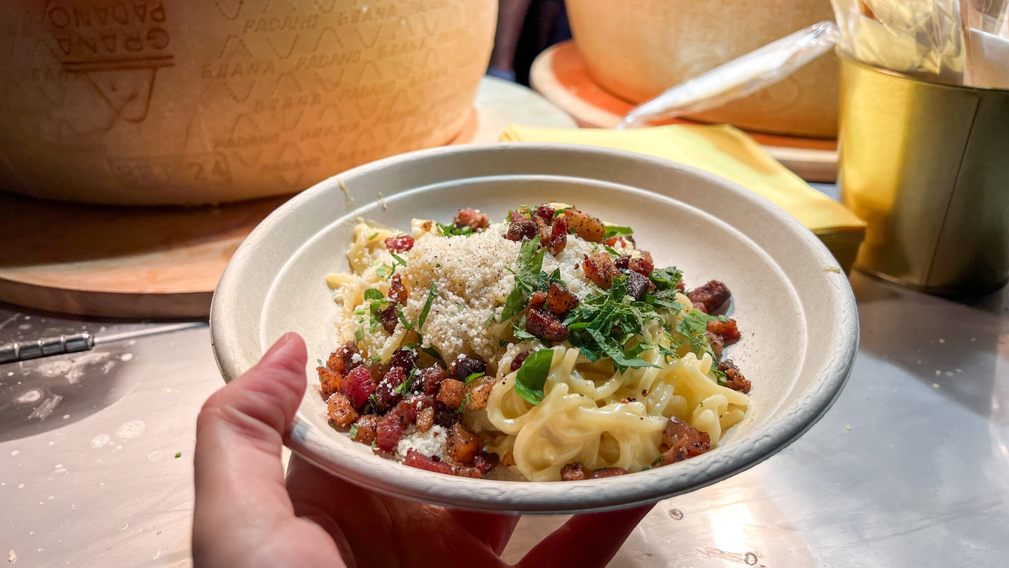 Fresh carbonara with parsley served in paper bowl.