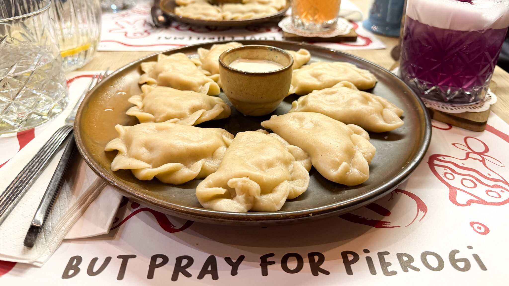 Plate of freshly boiled pierogi with sour cream.