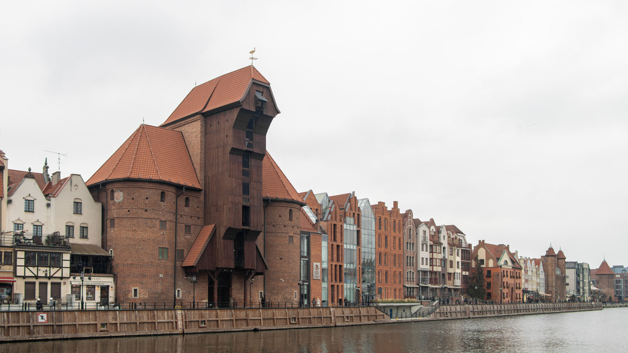 Old wooden crane structure along river in Gdansk.