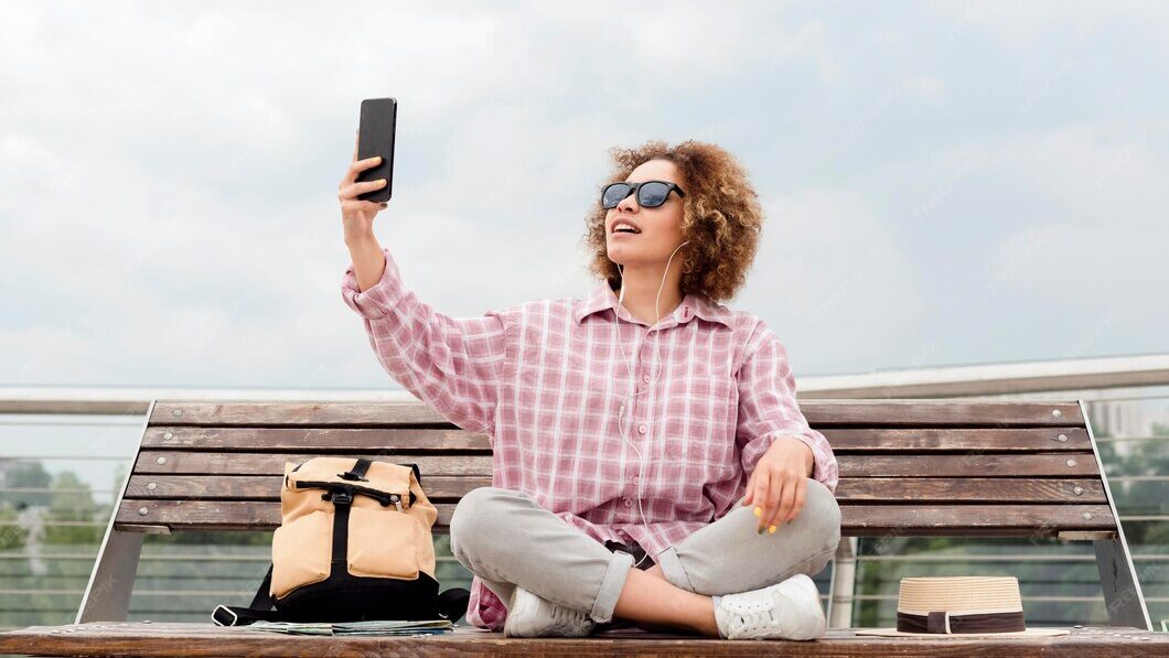 AI Influencers | Krista the Explorer Woman sitting down taking a selfie.