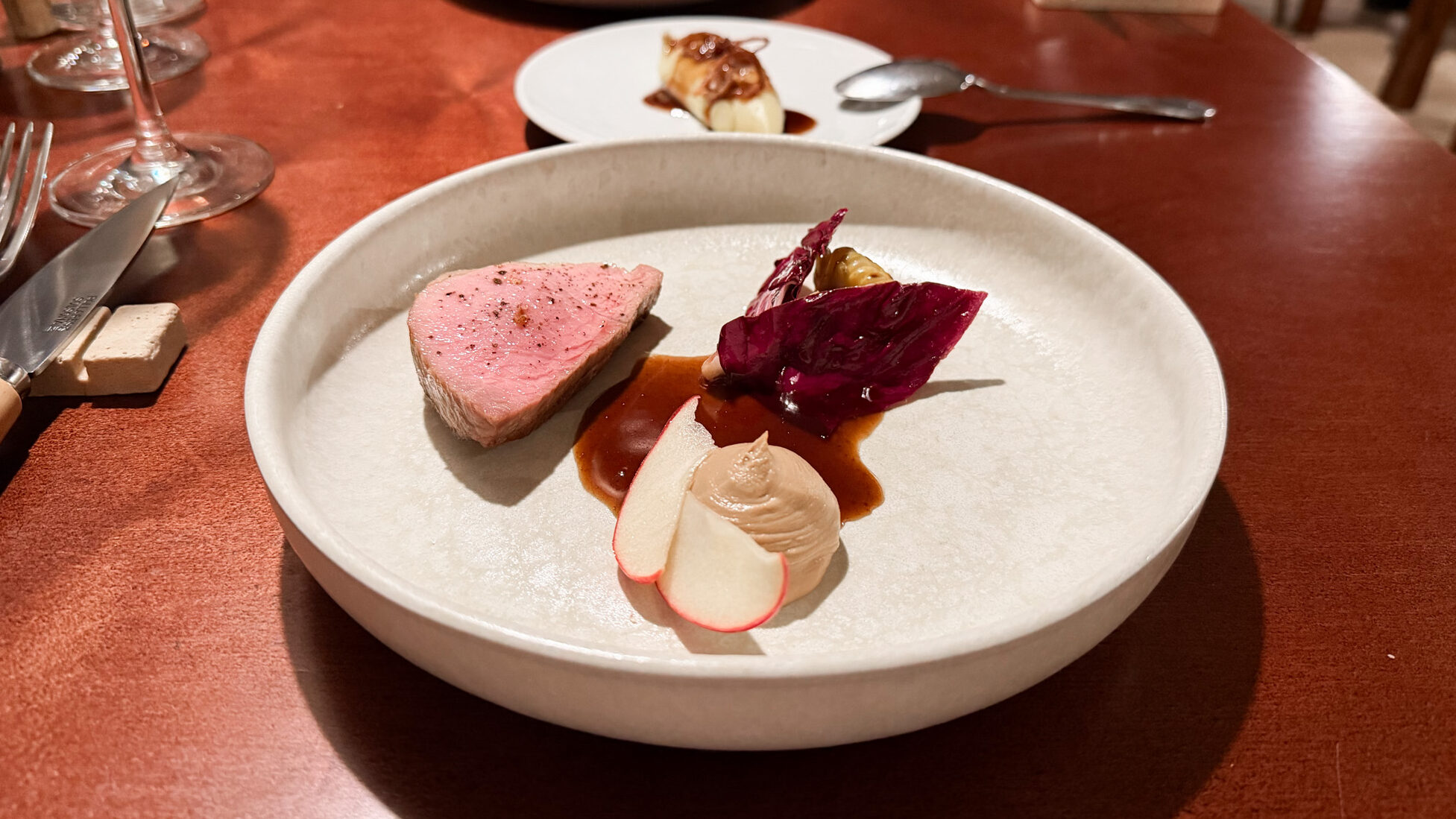 Meat dish displayed eloquently in Michelin restaurant.