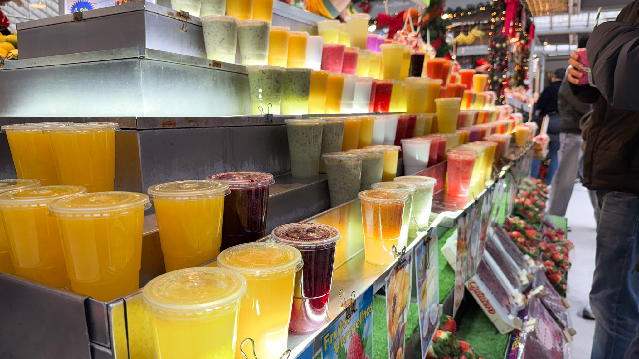 Selection of fresh juices on display in market.