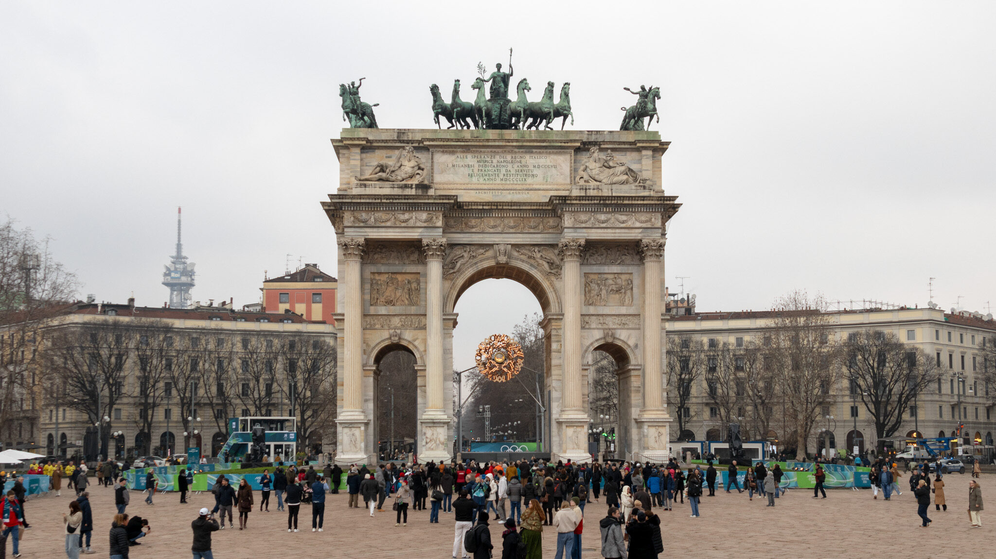 Large arch in Milan with Olympic flame in the centre.