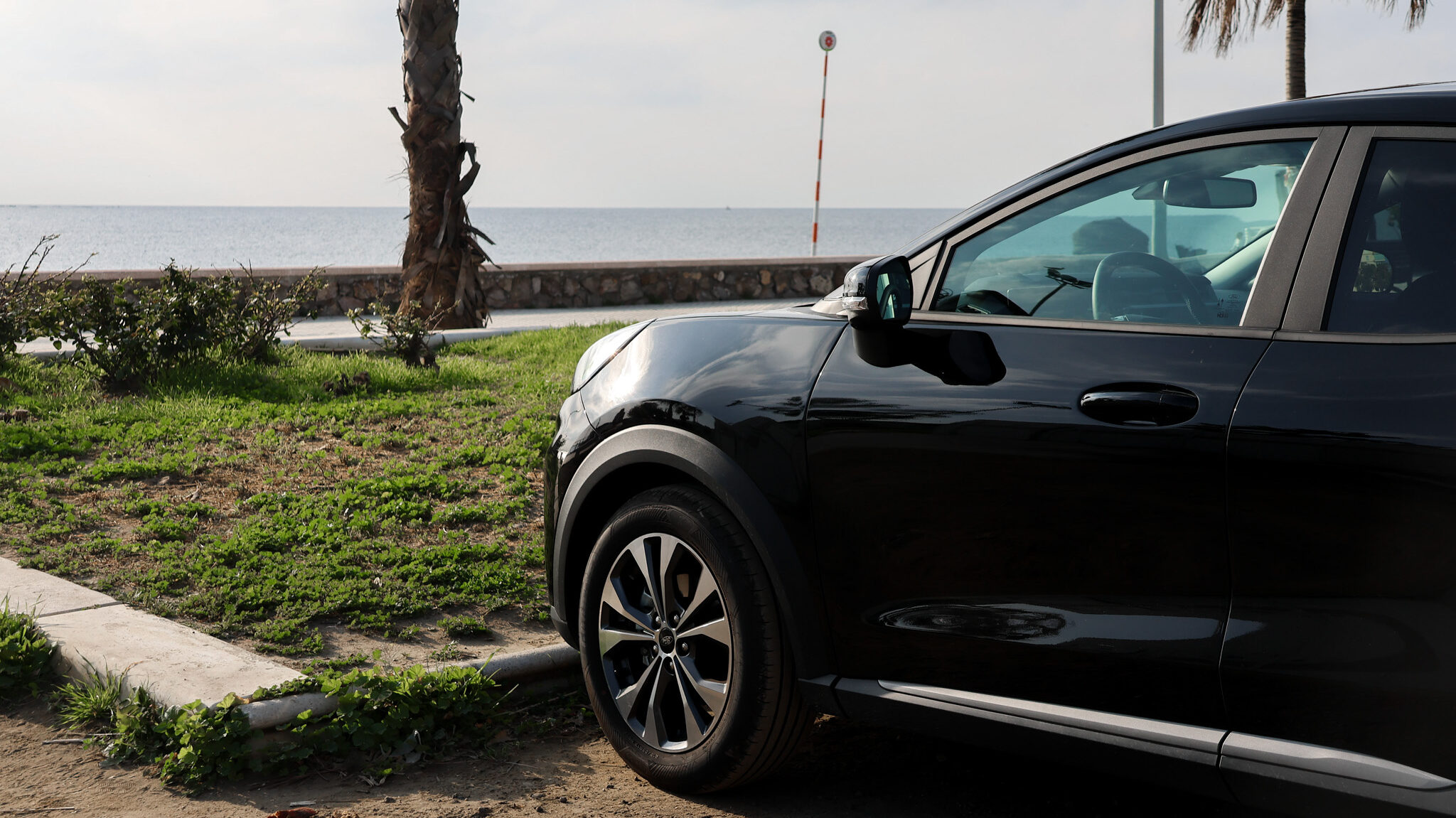 Marbella Rental | Krista the Explorer Black rental car parked in front of beach.