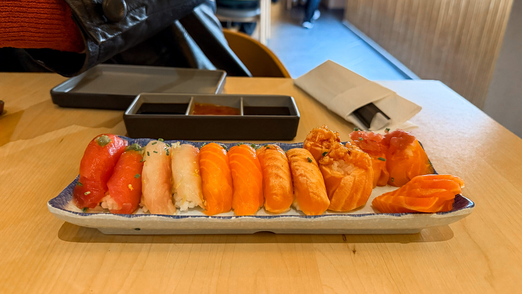 Long plate with fresh sushi in restaurant.