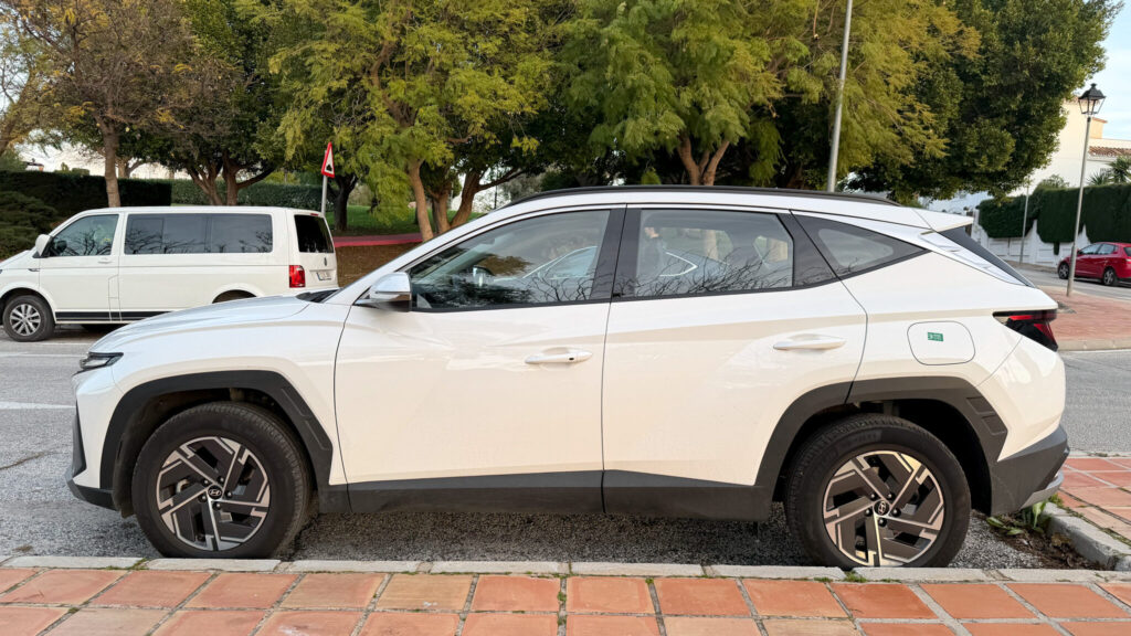 White SUV parked on street in Spain.