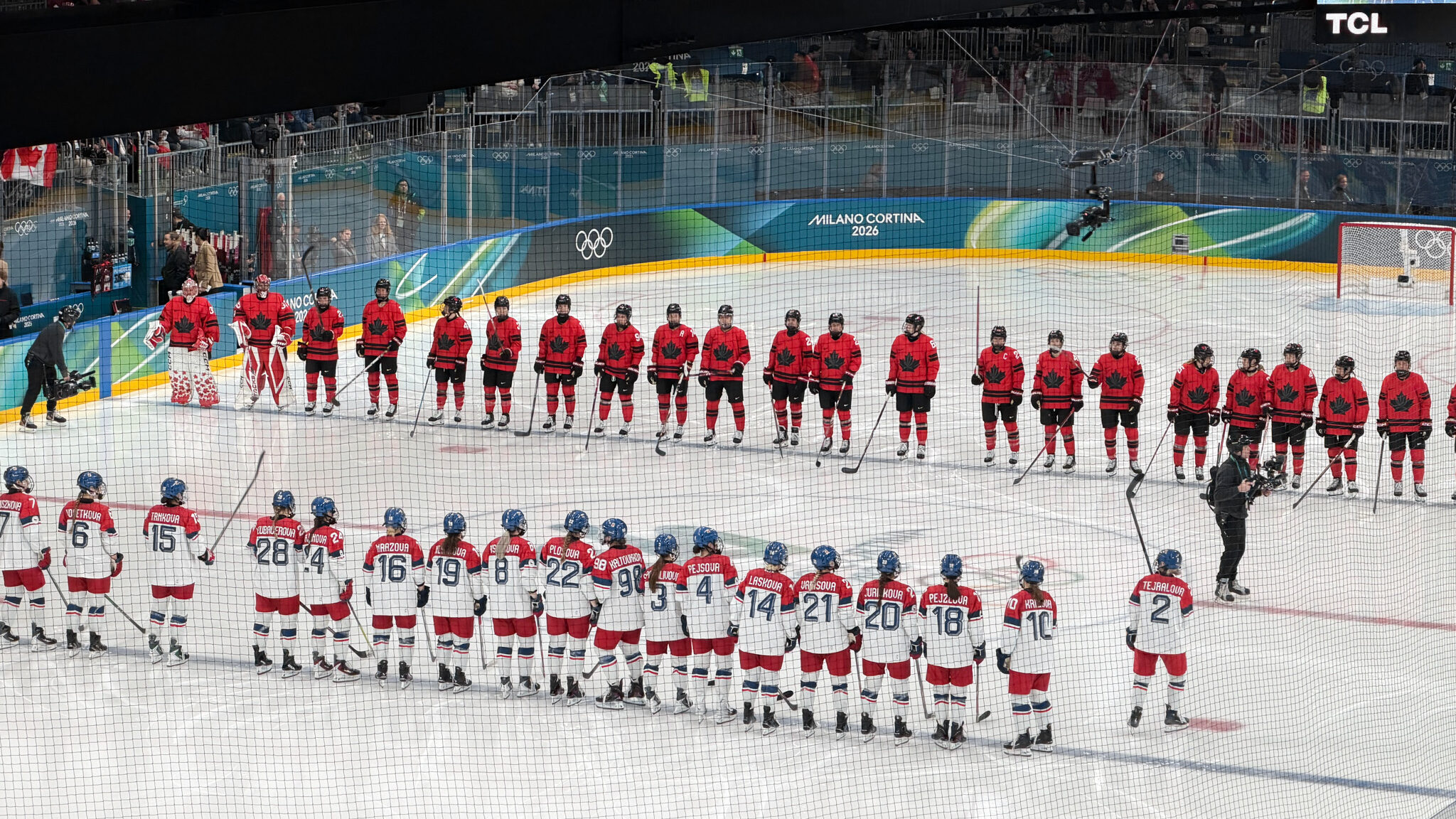 Two hockey teams lined up on ice before game.